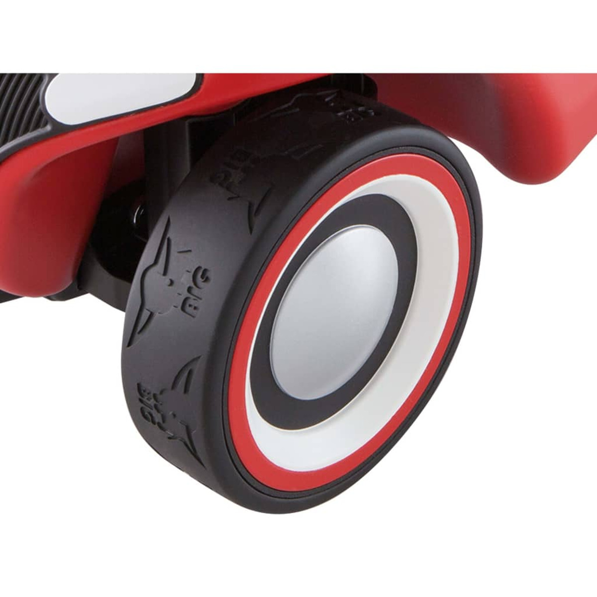 Zbliżenie koła czerwono-białego samochodu dla dziecka, pokazujące szczegóły opony z napisem 'BIG'.