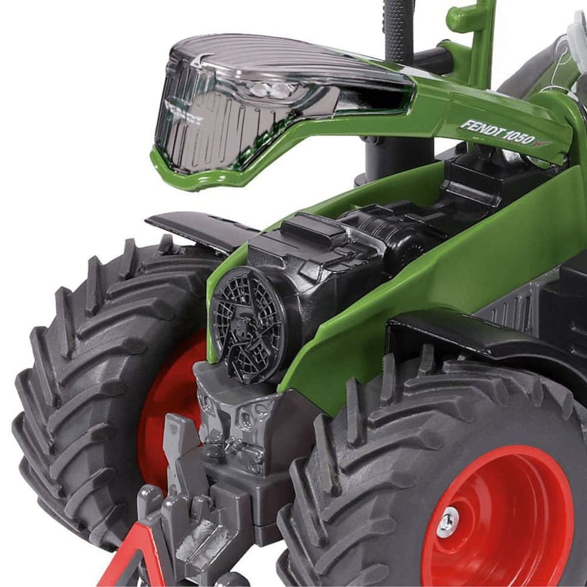 Zbliżenie zielono-czarnego ciągnika FENDT 1050. Widoczne czerwone koło.