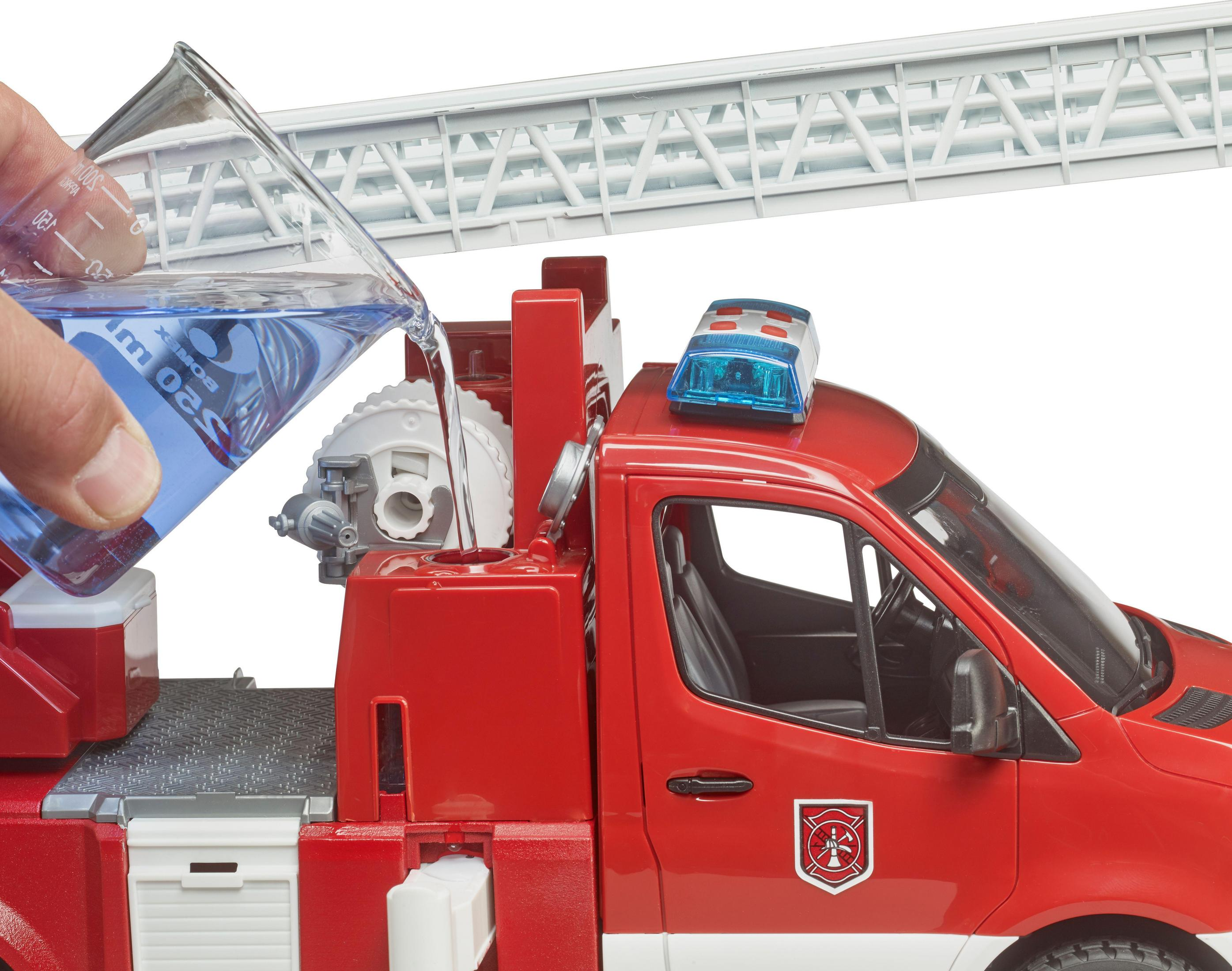 Zabawkowa straż pożarna napełniana wodą ze zlewki. Czerwony pojazd, białe tło.