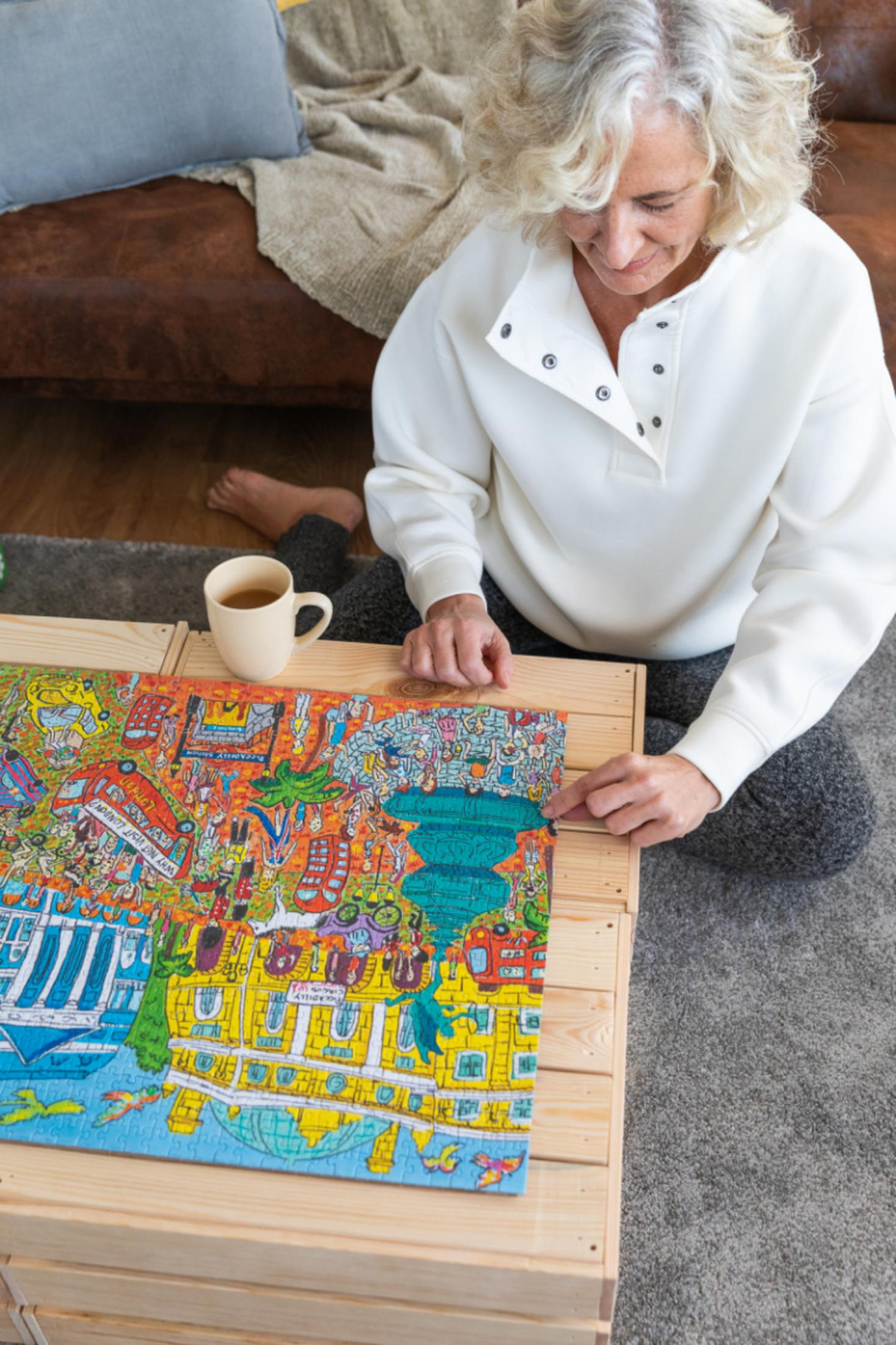 Frau, die ein buntes Puzzle auf einem Holztisch zusammensetzt. Brauner Couch-Hintergrund.