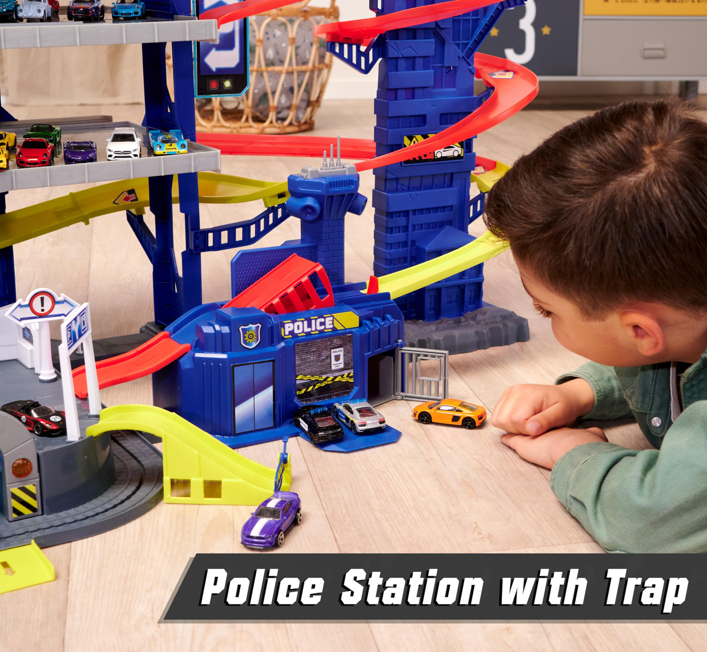 Ein Kind betrachtet eine Spielzeug-Polizeistation mit Autos und Rampen.