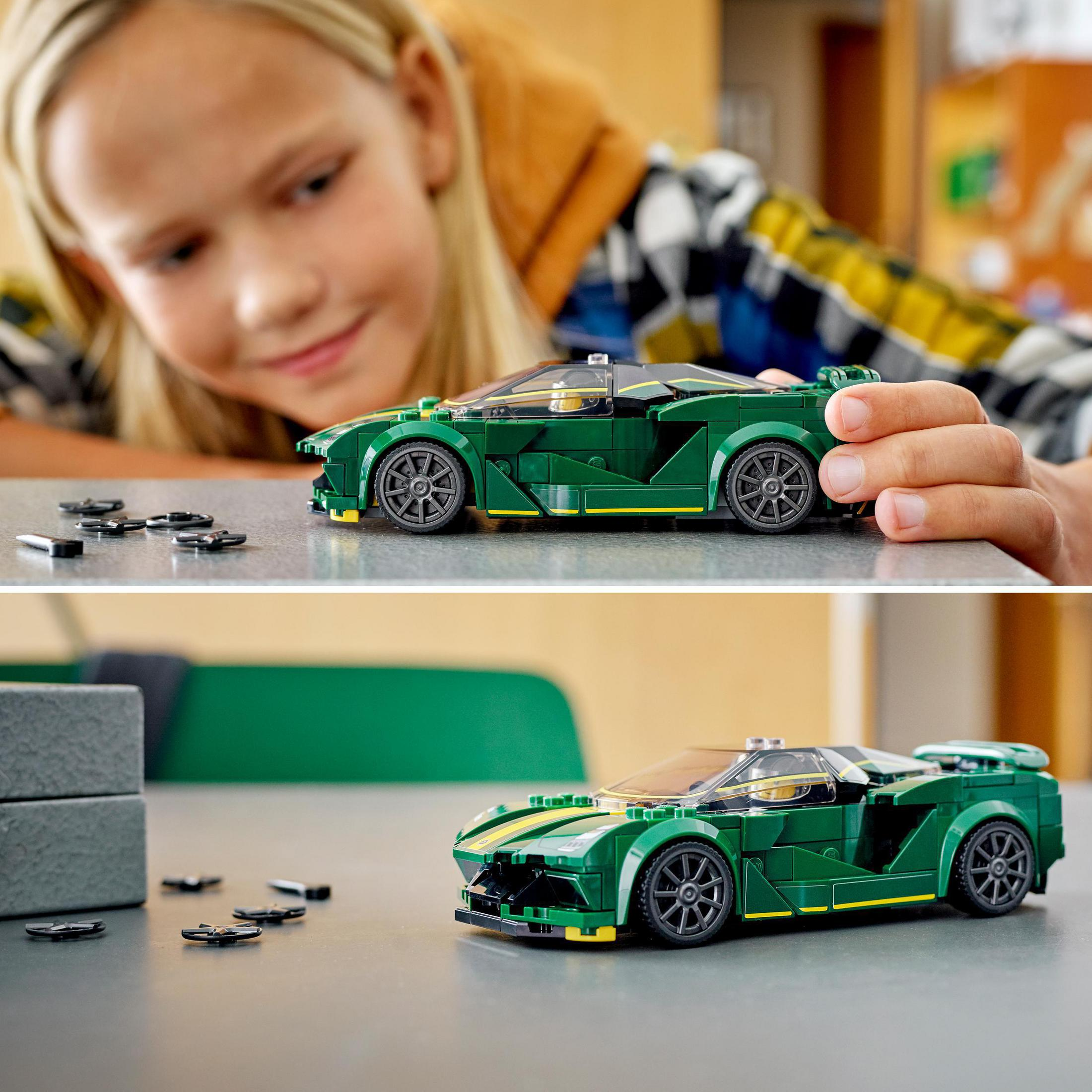 Kind betrachtet grünes Lego-Auto. Ein Auto ist zusammengebaut, ein anderes wird gebaut.
