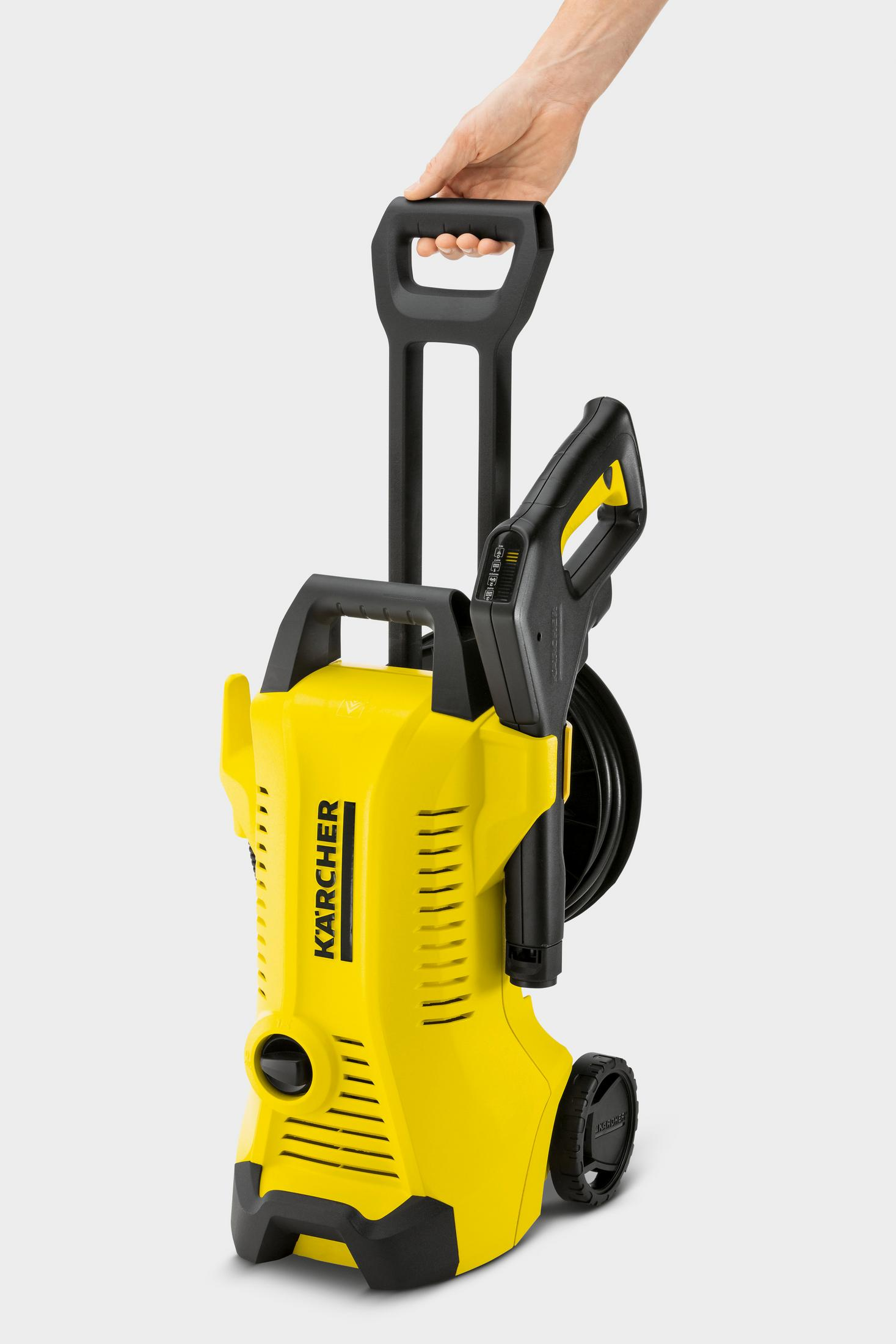Un'idropulitrice Karcher gialla e nera su ruote, tenuta in mano.