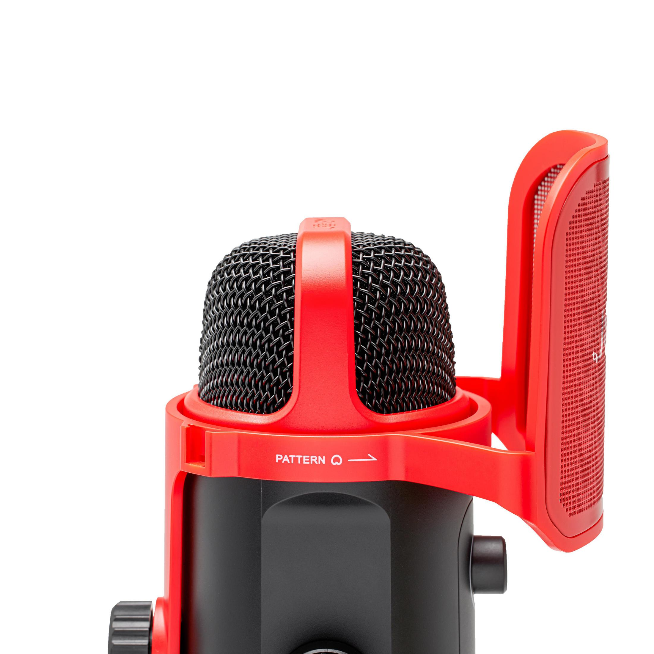 Un micrófono rojo con una cabeza de malla negra y una pantalla protectora roja.