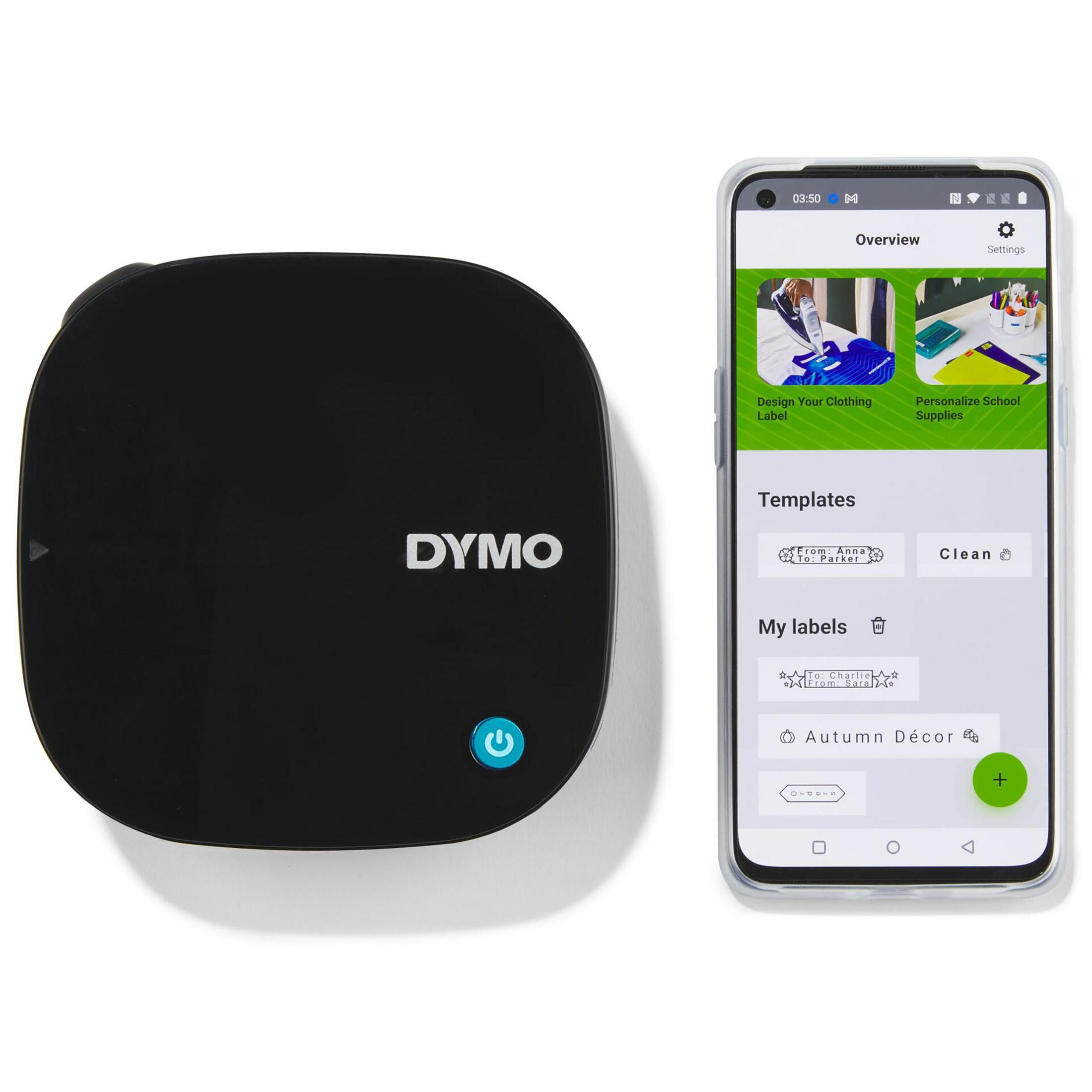Ein schwarzer DYMO-Etikettendrucker neben einem Telefon, das eine Etikettendesign-App anzeigt. Der Hintergrund ist weiß.