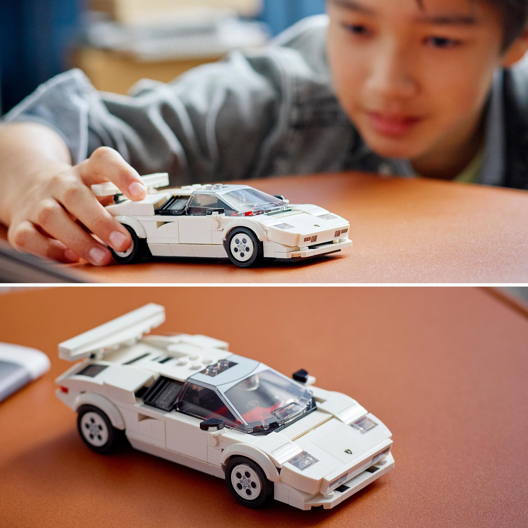Ein Kind betrachtet ein weißes Lego-Automodell. Das Auto ist ein Lamborghini Countach.
