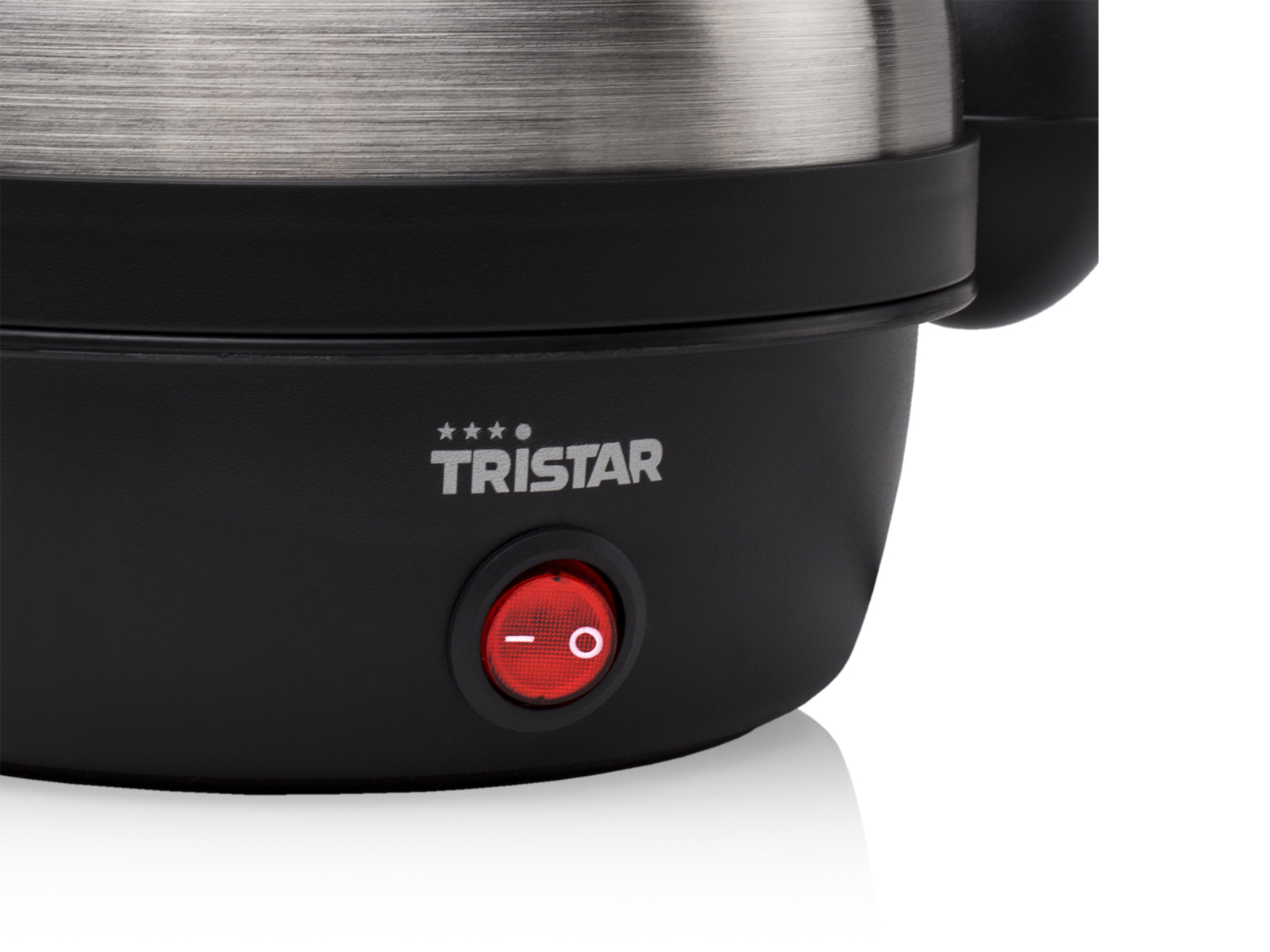 Zbliżenie czarnego i stalowego czajnika elektrycznego z czerwonym przyciskiem.