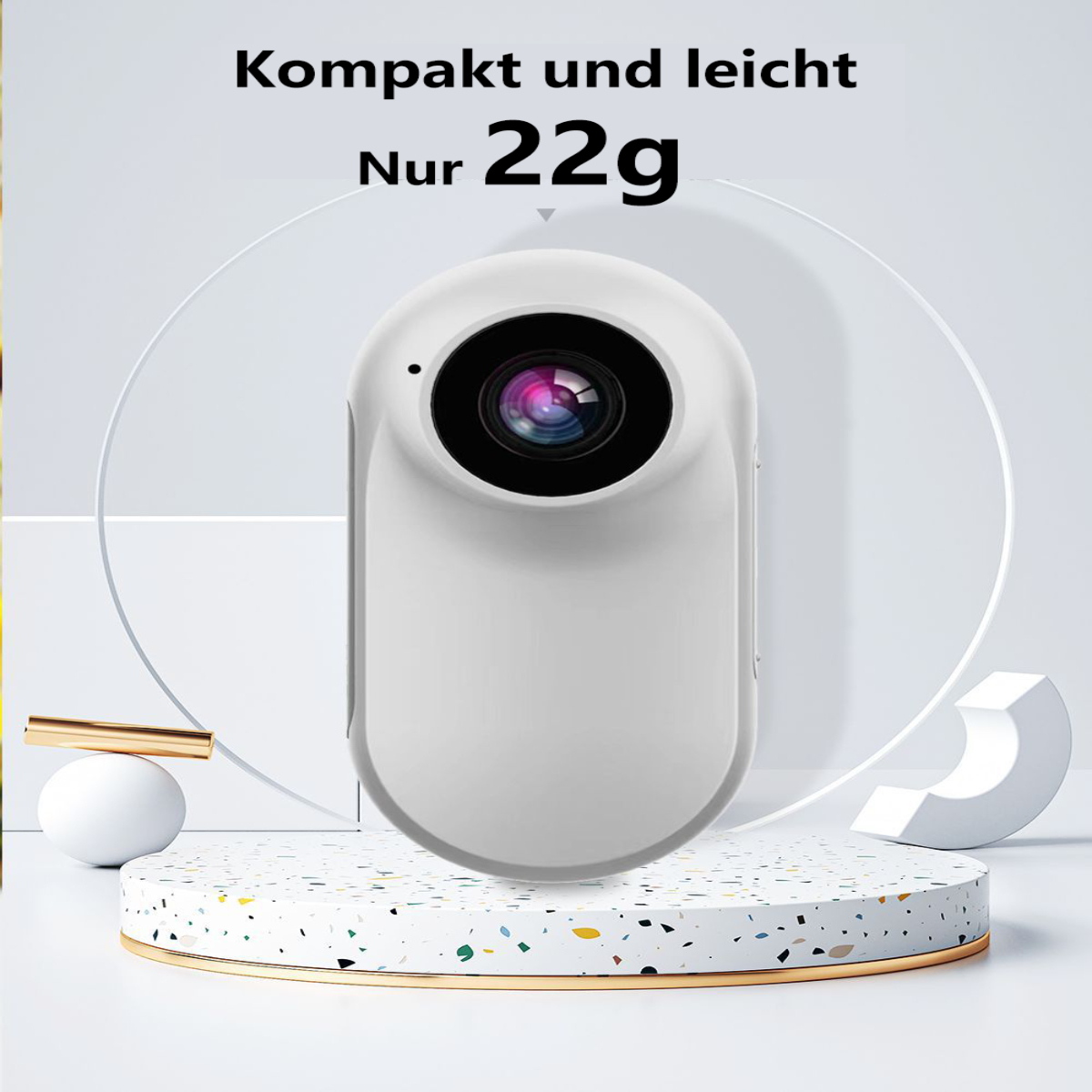 Eine weiße Kamera mit schwarzem Objektiv und dem Text „Kompakt und leicht Nur 22g“ auf einem Podest.