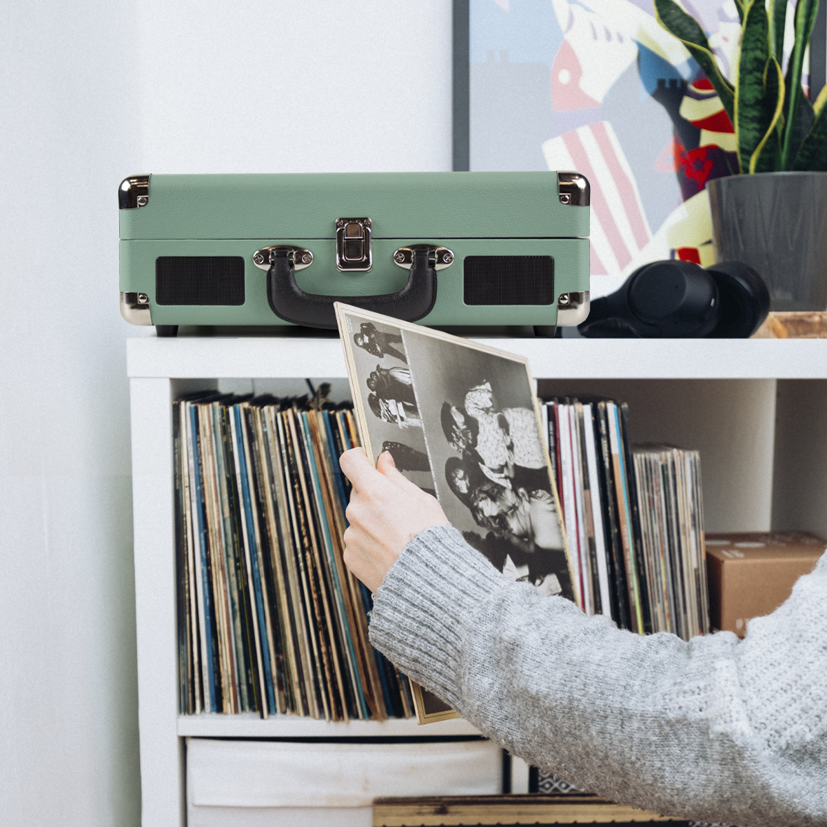 Turkusowy, zielony odtwarzacz płyt winylowych na półce z płytami i słuchawkami.