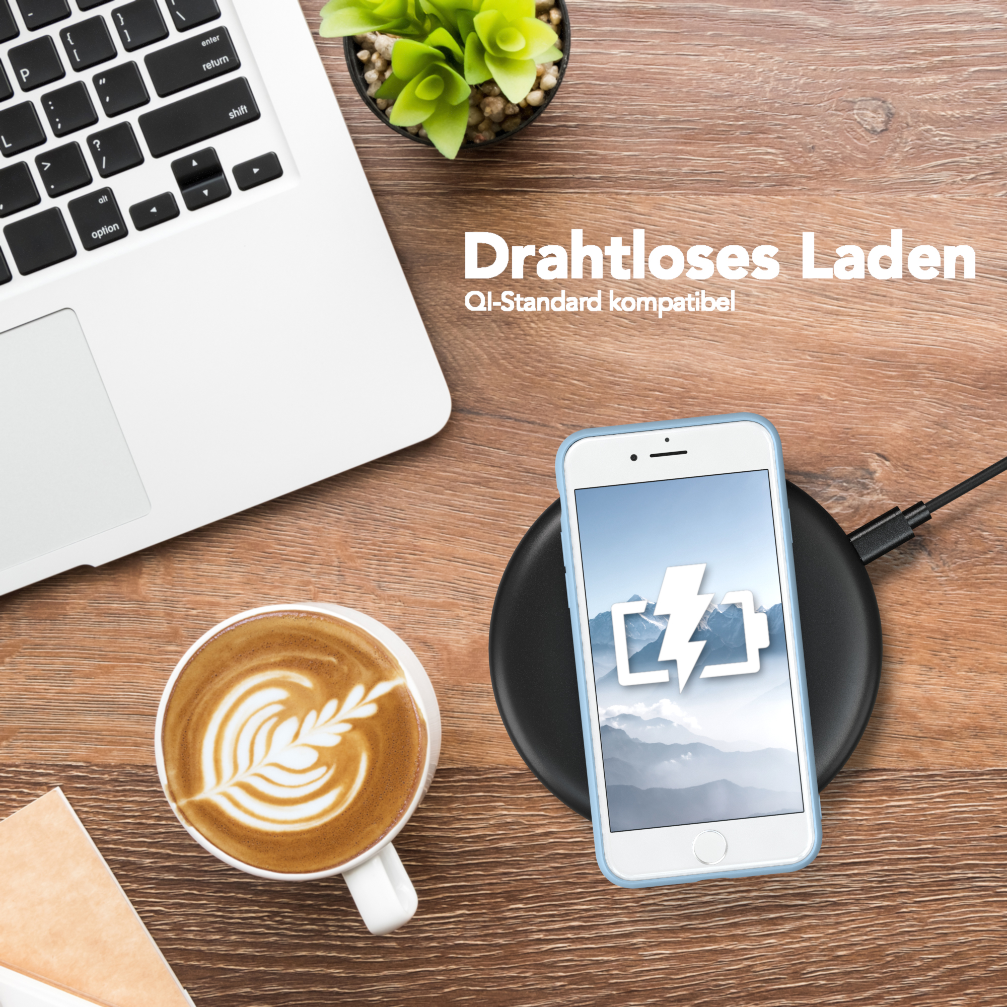 Ein schwarzes kabelloses Ladegerät mit einem Telefon darauf, eine Kaffeetasse und ein Laptop auf einem Holztisch.