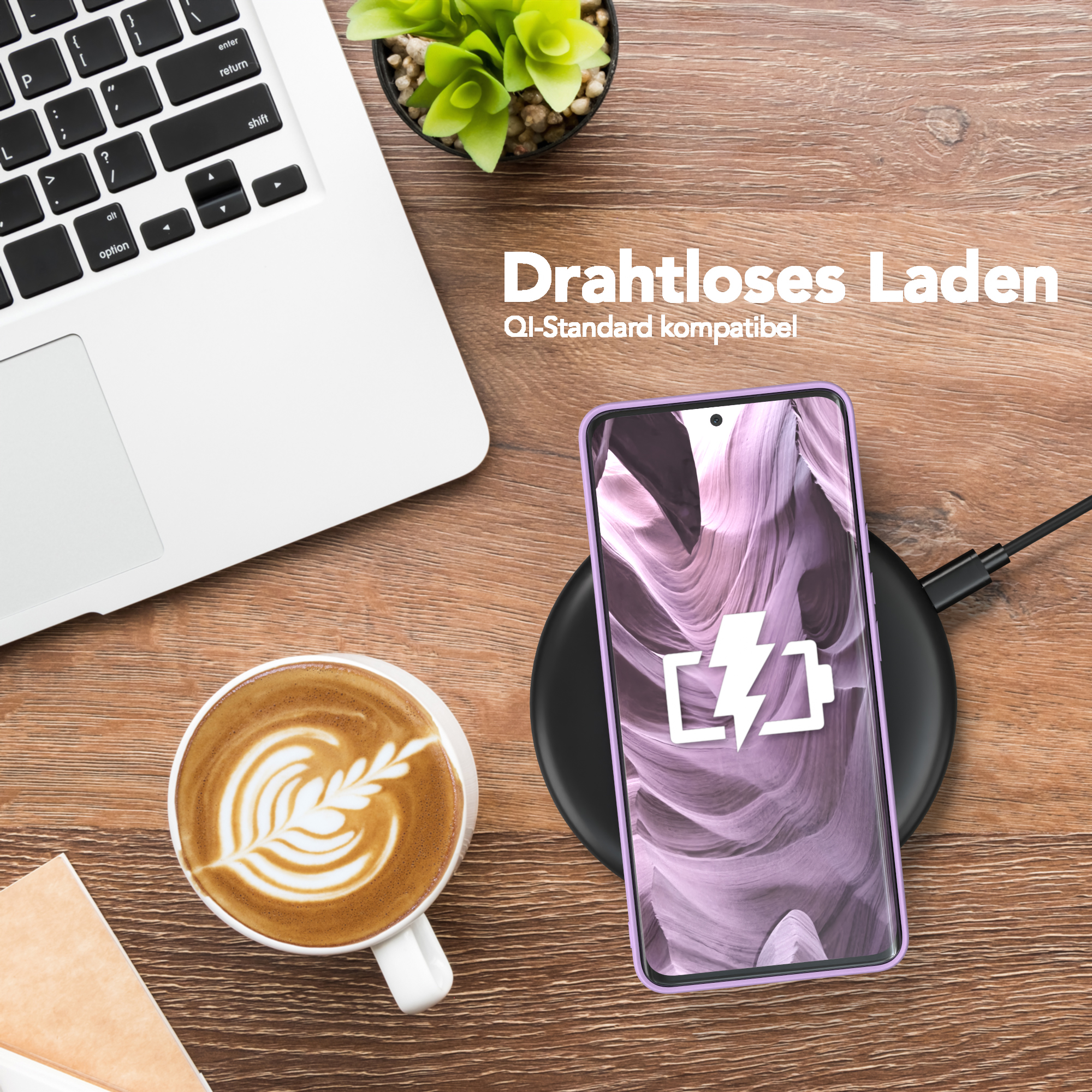 Ein Telefon, das kabellos auf einem Pad geladen wird, mit einer Kaffeetasse und einem Laptop daneben.