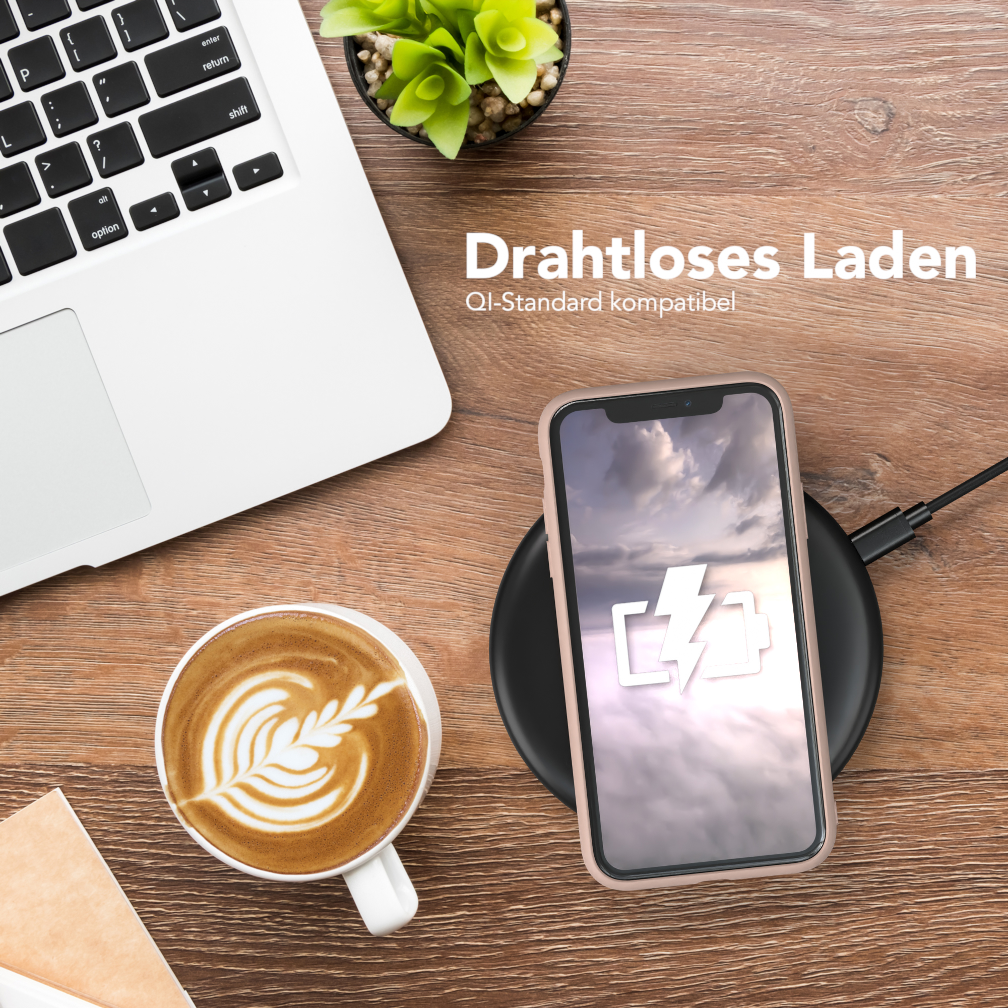 Laptop, Telefon auf Ladegerät und Kaffeetasse auf einem Holztisch. Fokus auf dem Telefon.