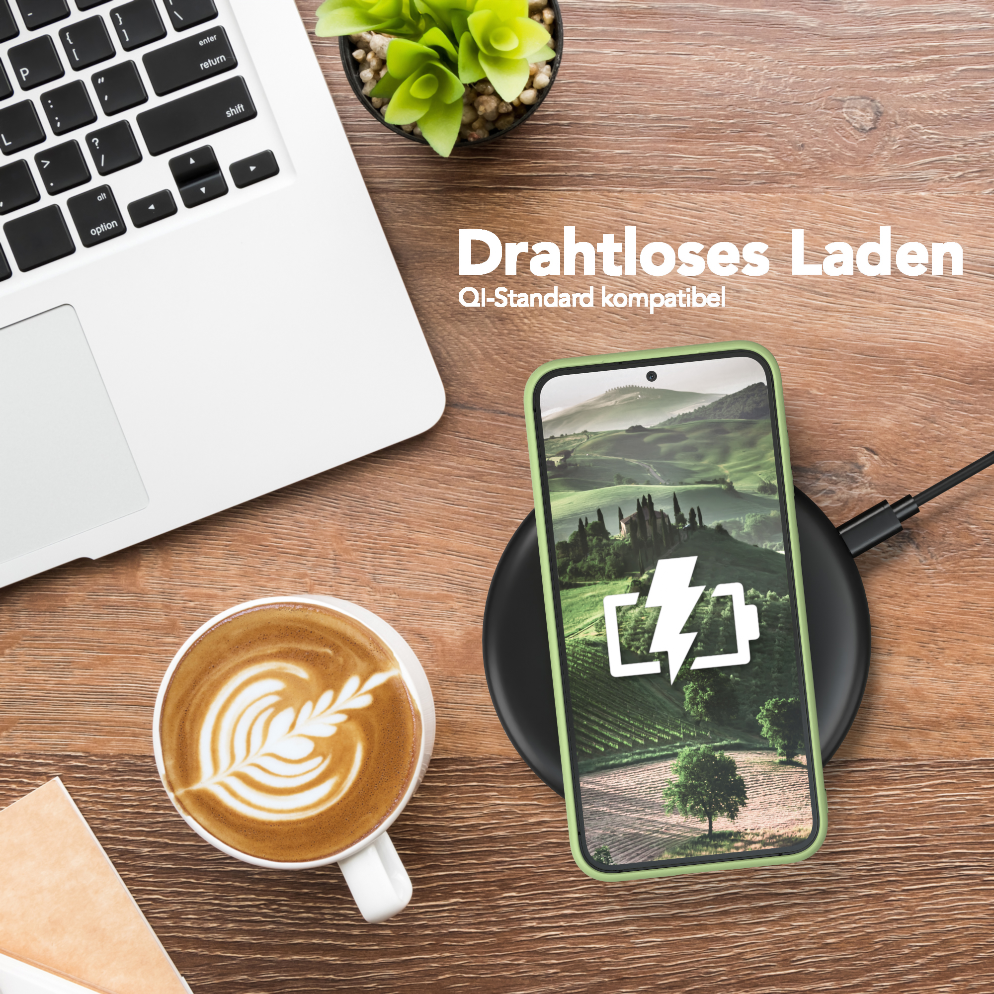 Ein Telefon auf einem kabellosen Ladegerät neben einem Laptop, Kaffee und einer Pflanze.