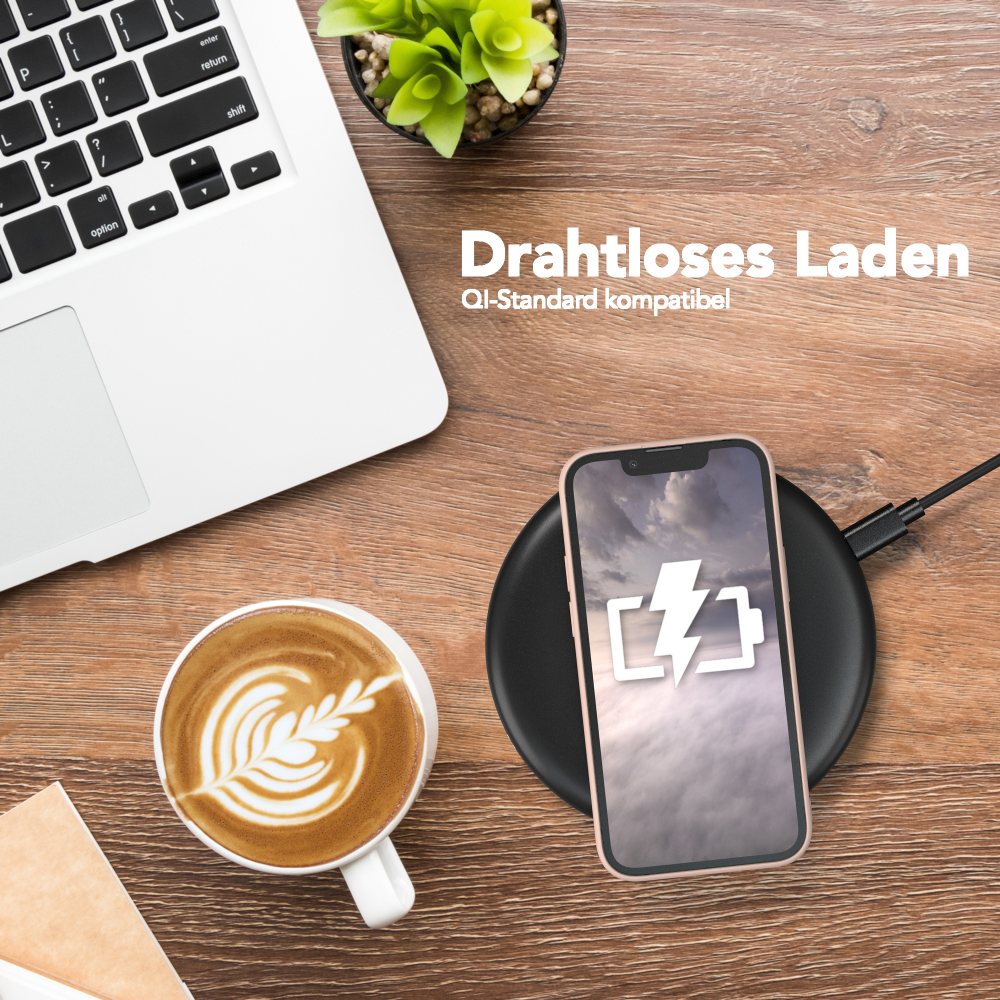 Ein Telefon, das auf einem kabellosen Ladegerät in der Nähe eines Laptops und eines Kaffees aufgeladen wird.
