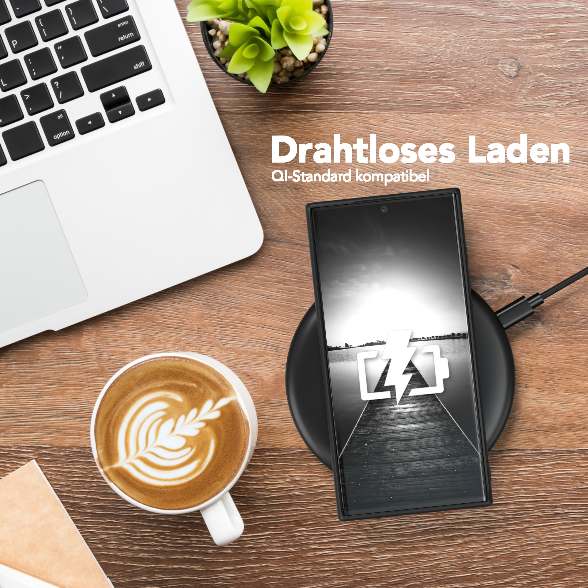 Laptop, Kaffeetasse und Telefon-Ladepad auf einem Holztisch. Das Telefon zeigt einen Blitz.