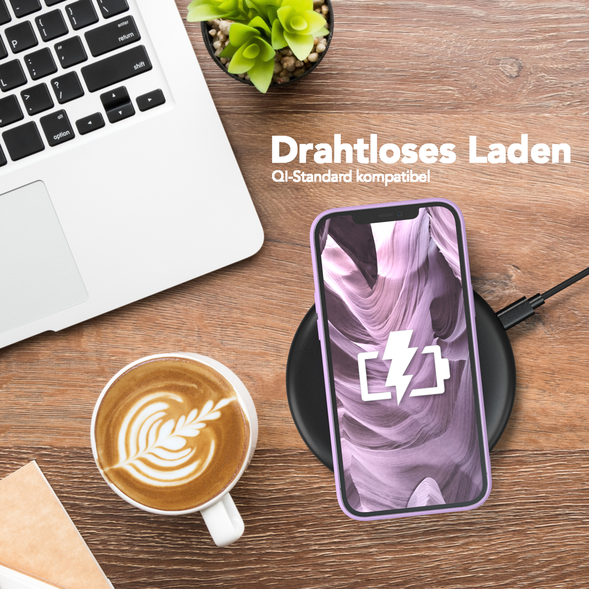 Telefon mit lila Hülle lädt kabellos auf einem schwarzen Pad neben einem Laptop und einer Kaffeetasse.