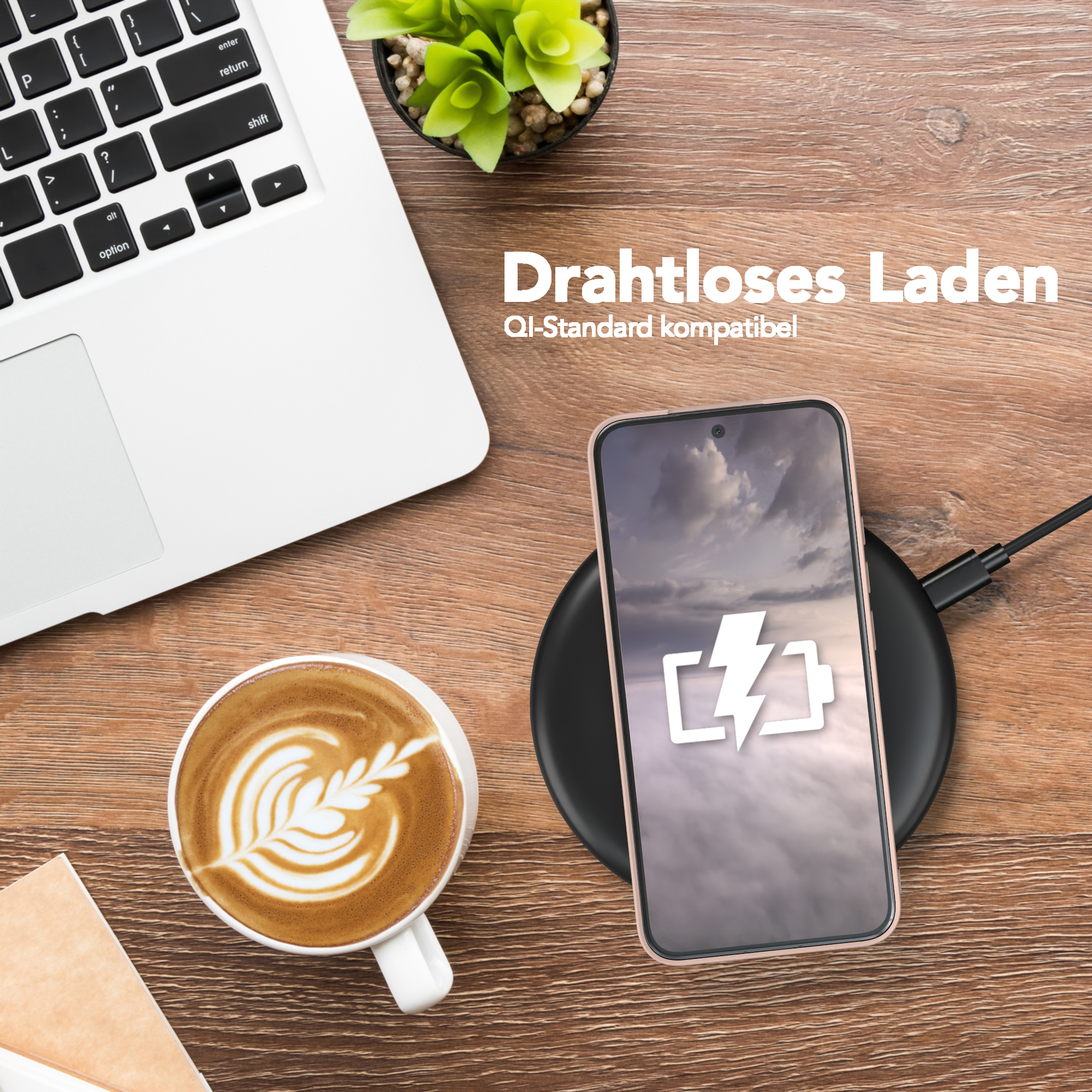 Ein Telefon, das kabellos neben einem Laptop und einer Tasse Kaffee geladen wird.