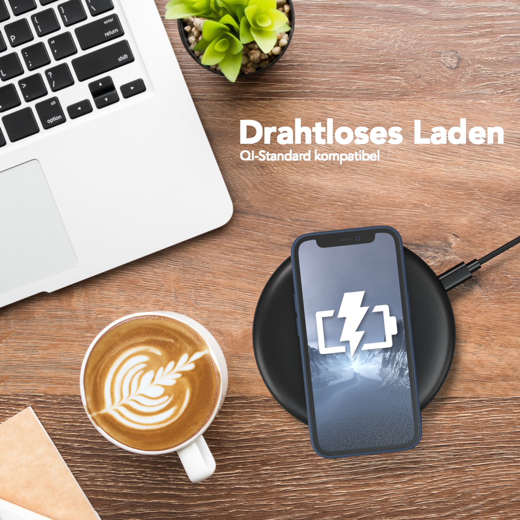 Laptop mit Ladetelefon, Kaffee und Pflanze auf einem Holztisch.