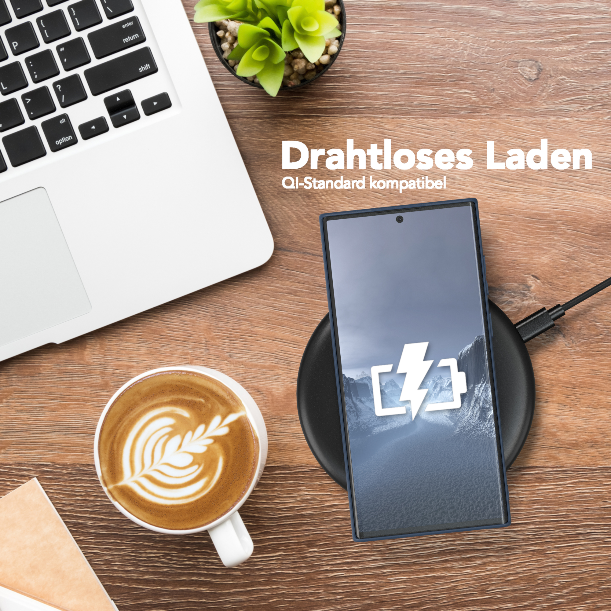 Ein Laptop, eine Kaffeetasse, ein Telefon auf einem Ladegerät und eine Pflanze auf einem Holztisch.
