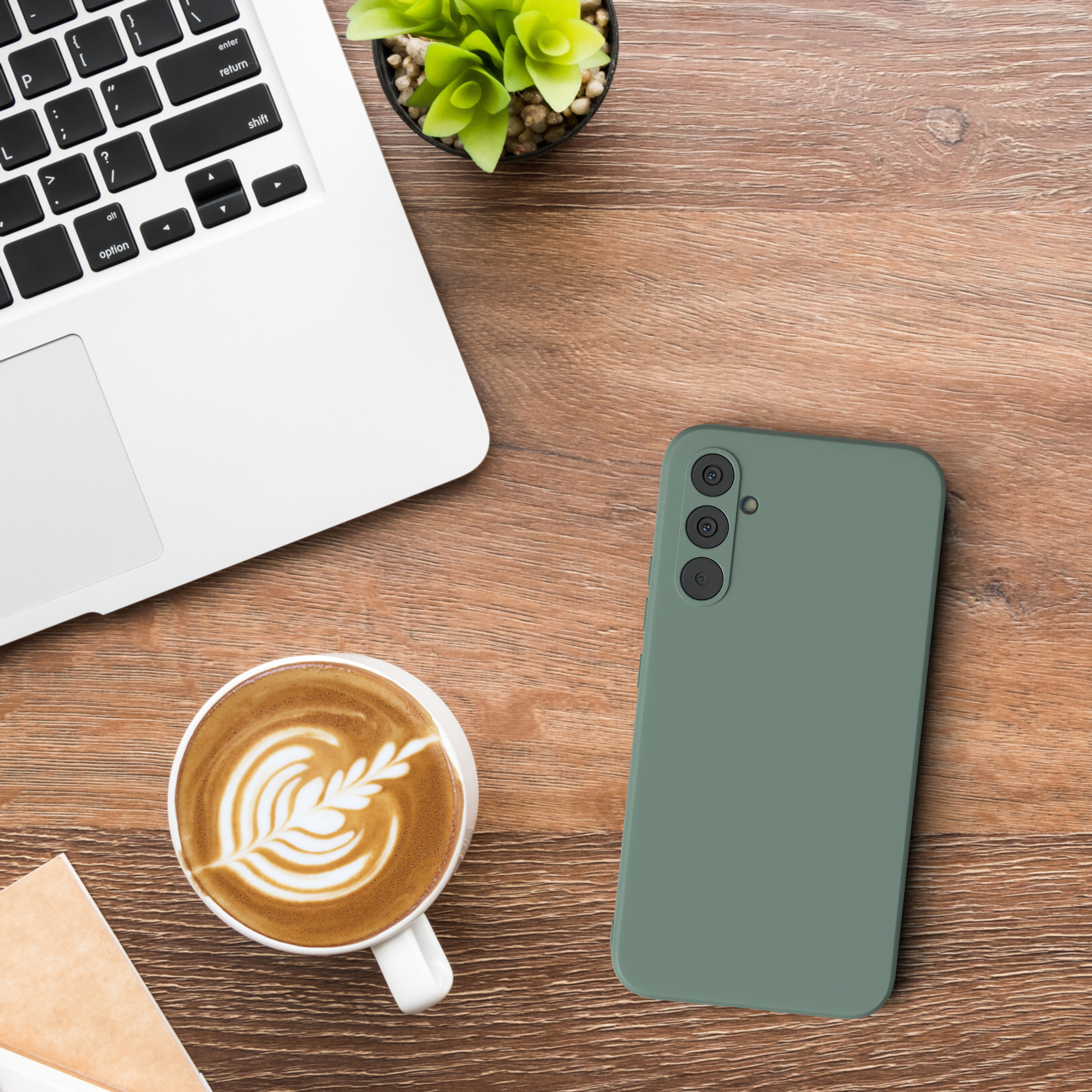 Ein Telefon und ein Laptop mit einer Kaffeetasse auf einem Holztisch.