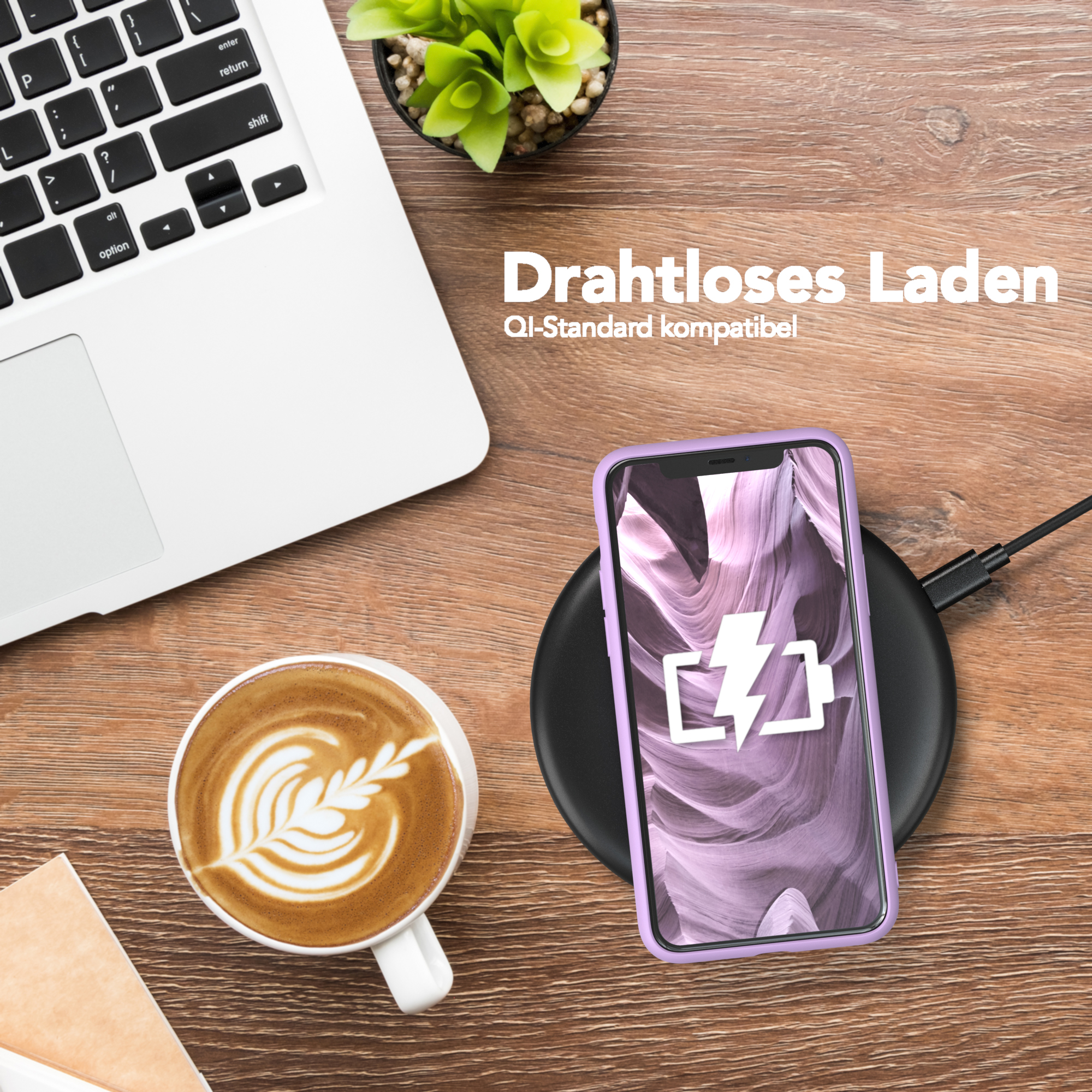 Ein Laptop, eine Tasse Kaffee, ein Telefon, das drahtlos auf einem Holztisch geladen wird.