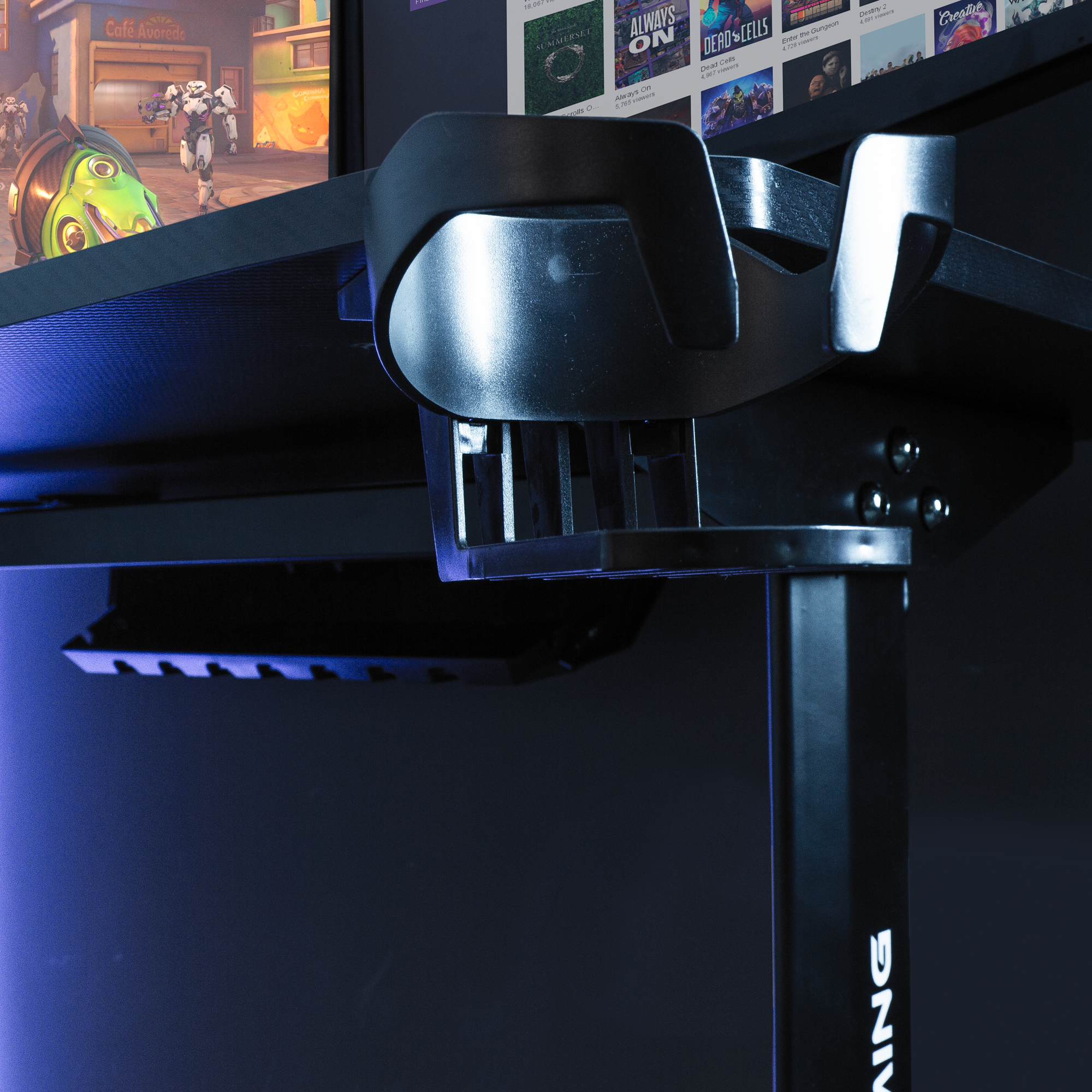 Gaming-Schreibtisch mit Monitor, der ein Spiel zeigt. Schwarzer Schreibtisch mit schwarzem Ständer.