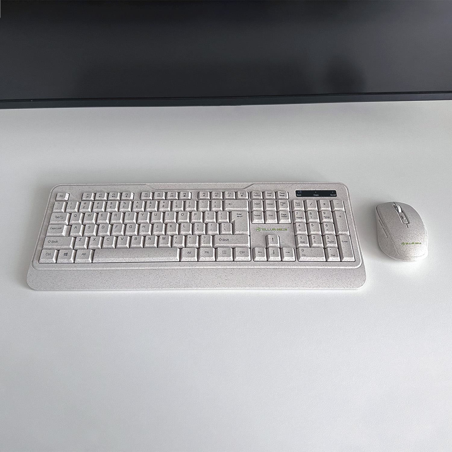 Jasnoszara klawiatura i mysz na białej powierzchni, z czarnym monitorem w tle.