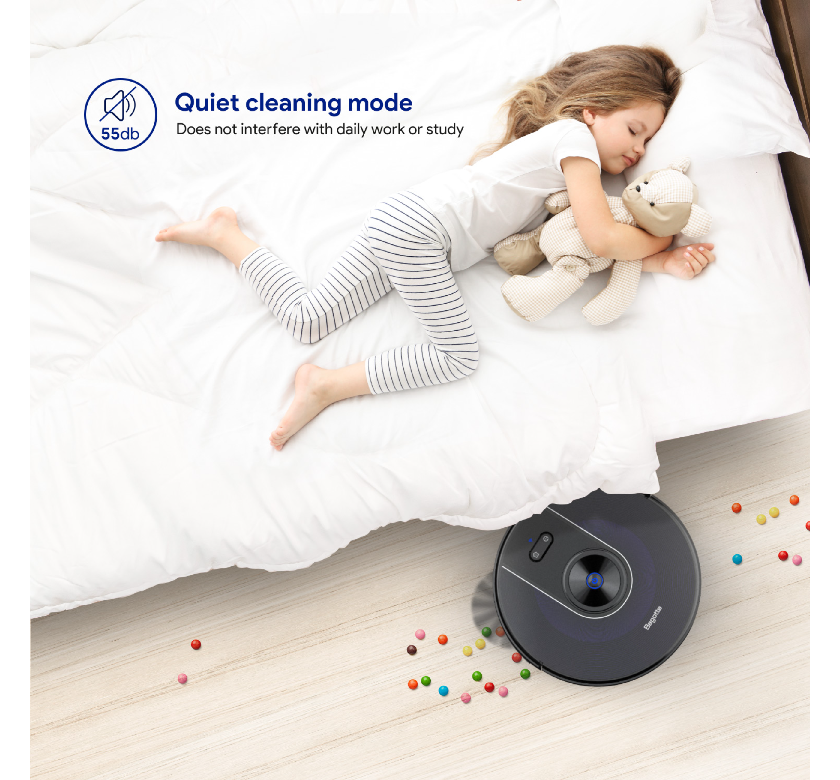 Ein Kind schläft auf einem Bett mit einem Spielzeug. Ein Roboter-Staubsauger steht auf dem Boden.
