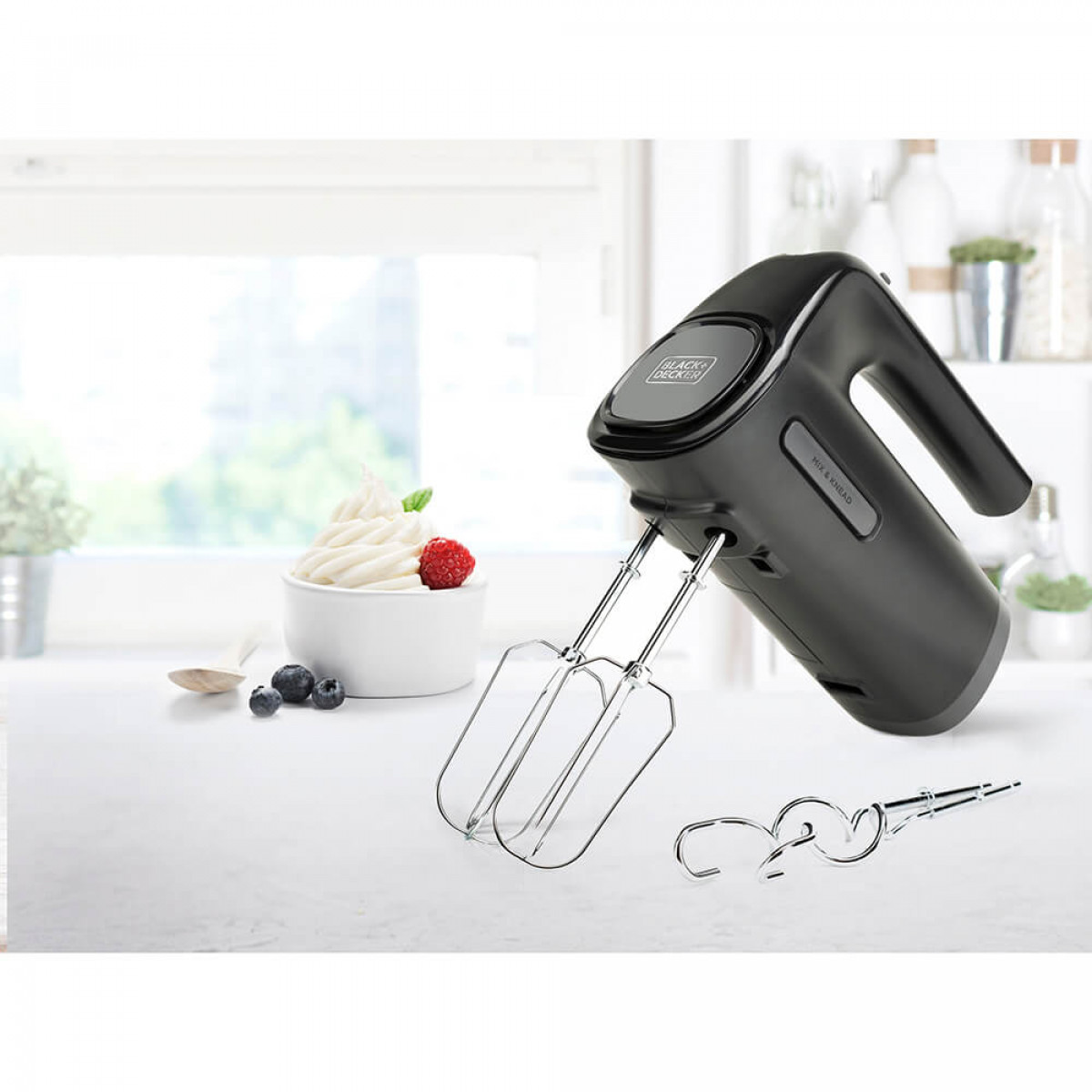 Frullatore a immersione Black+Decker nero e argento con accessori su un bancone bianco.