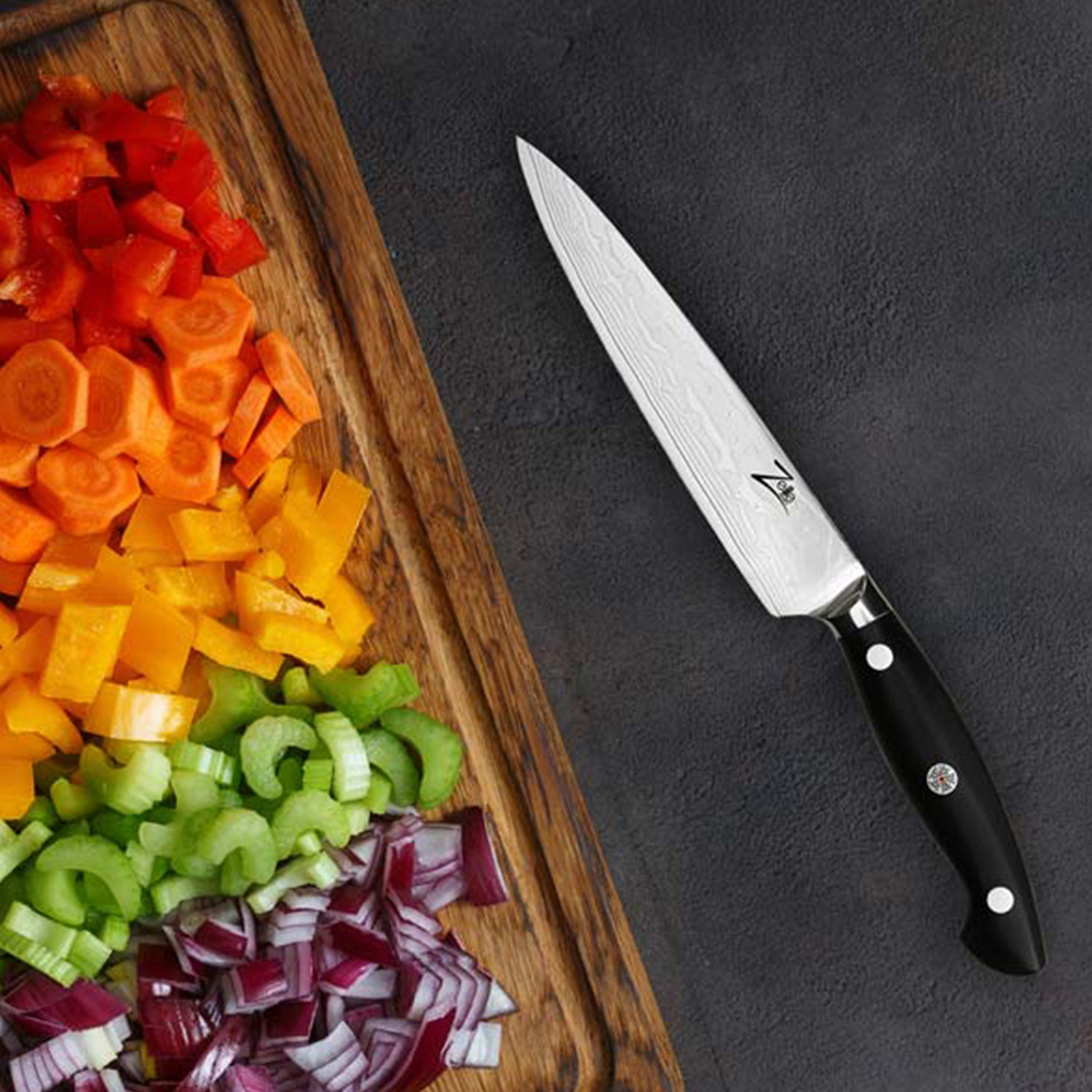 Ein Messer mit schwarzem Griff neben gekochten Rippchen, Sauce, Pinsel und Tomaten.