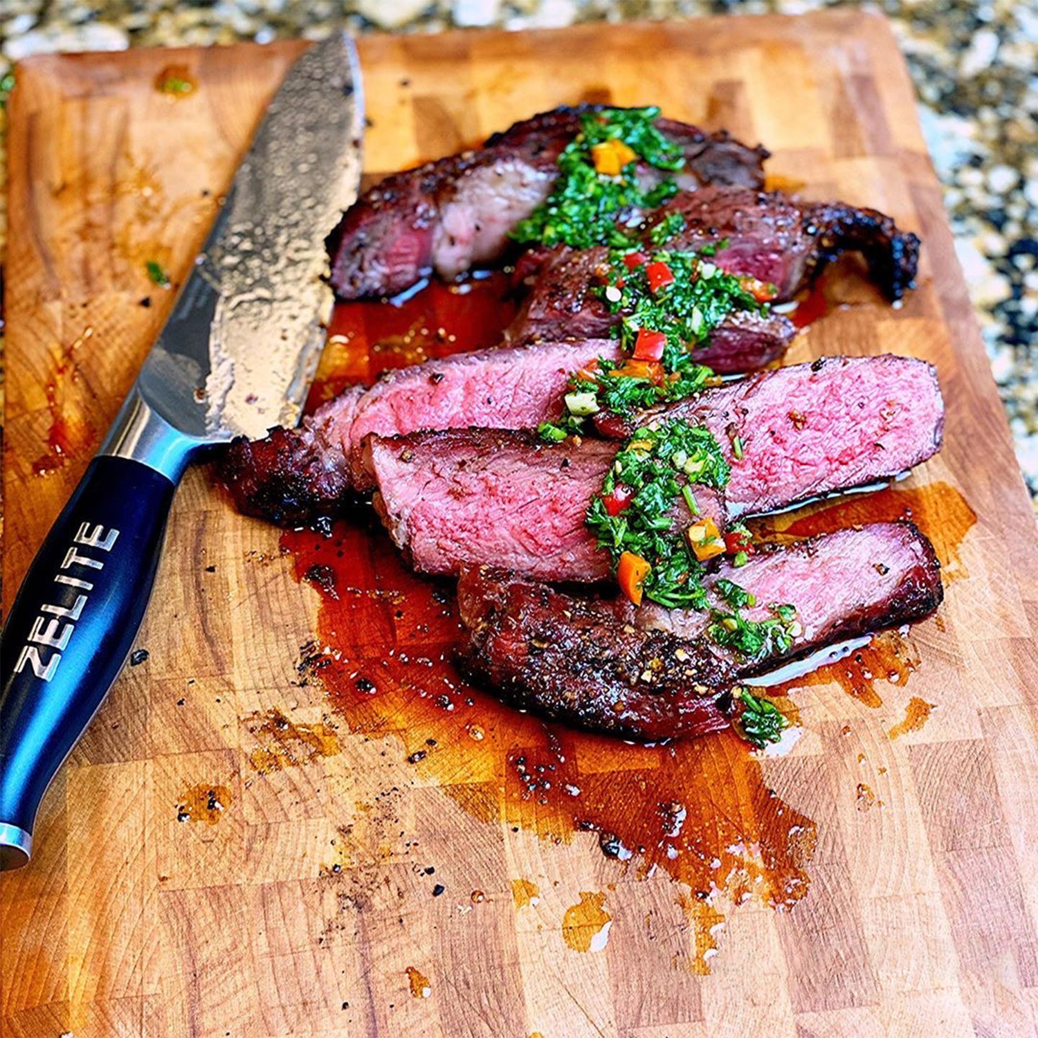 Geschnittenes, gebratenes Steak mit grünen Kräutern, neben einem Messer mit blauem Griff auf einem Holzbrett.