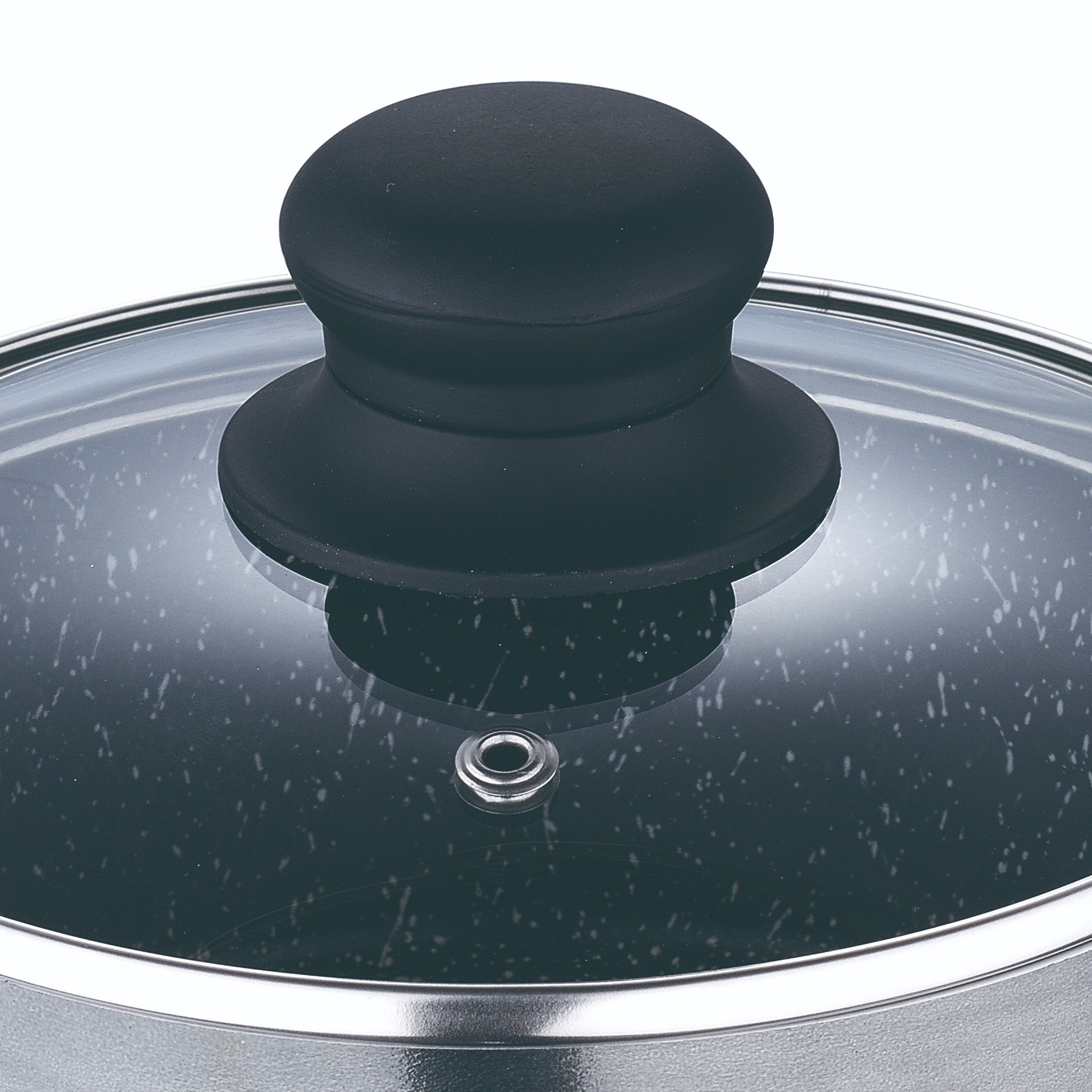 Primer plano de una tapa de olla con asa negra. La tapa es de vidrio con un diseño negro moteado.