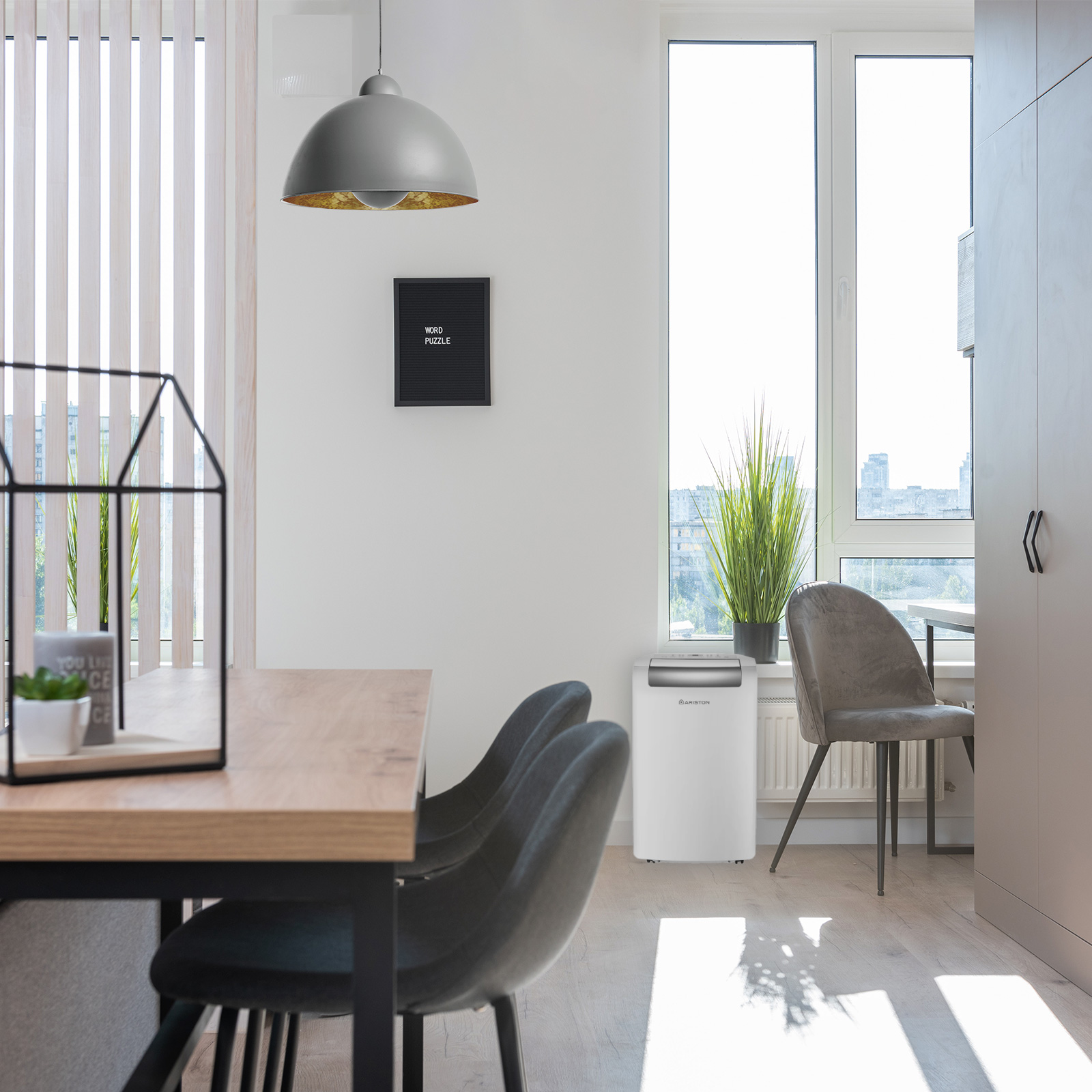 Toma interior de un comedor con paredes blancas y una ventana. Hay un aire acondicionado.