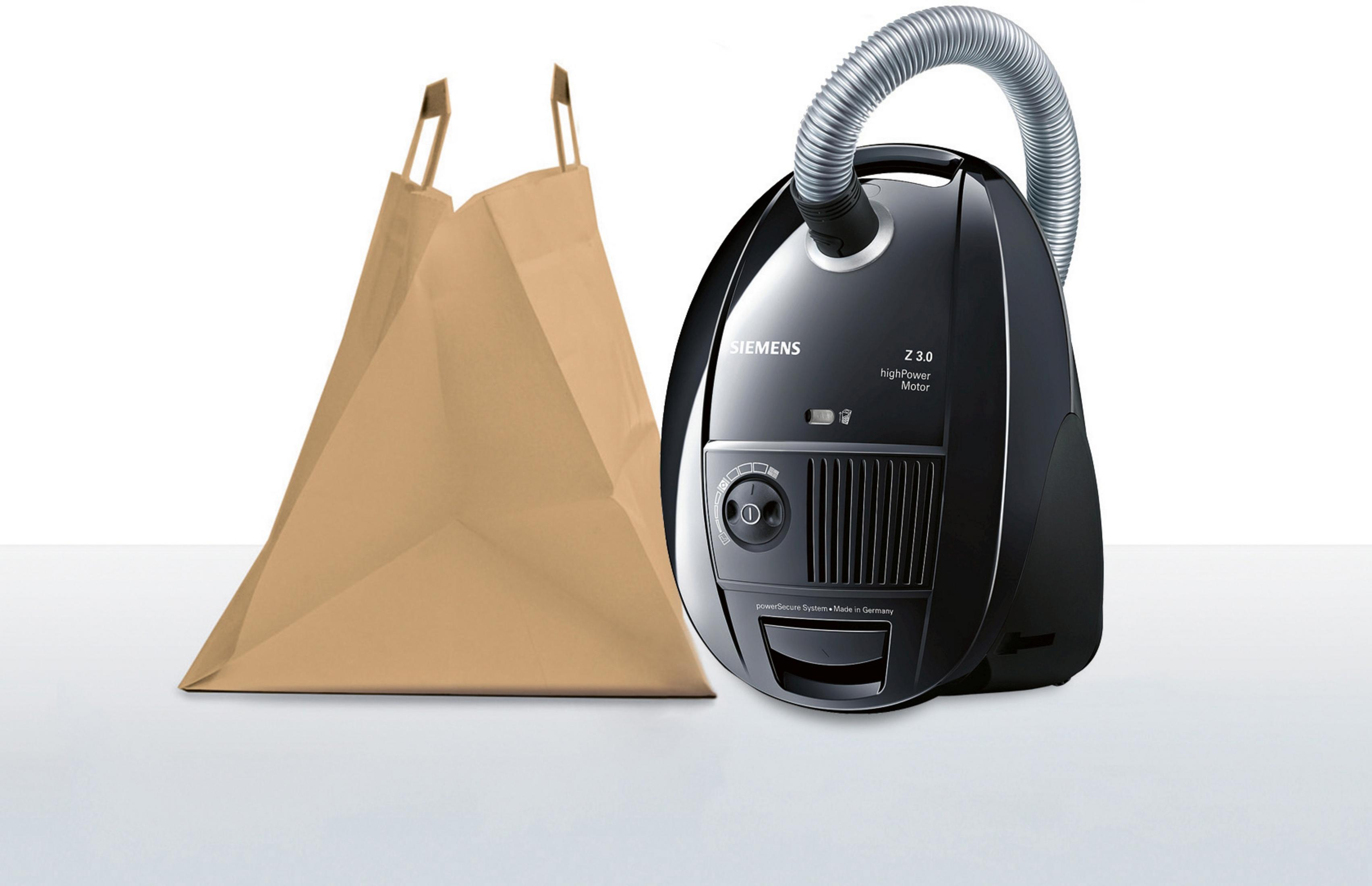 Ein Staubsauger und eine braune Papiertüte stehen auf einer weißen Oberfläche. Der Staubsauger ist schwarz.