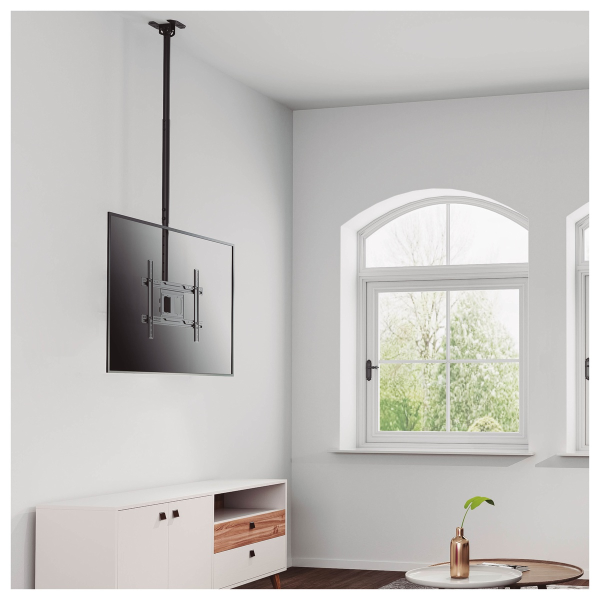 Una pantalla de TV colgada del techo, con pared y ventana blancas.