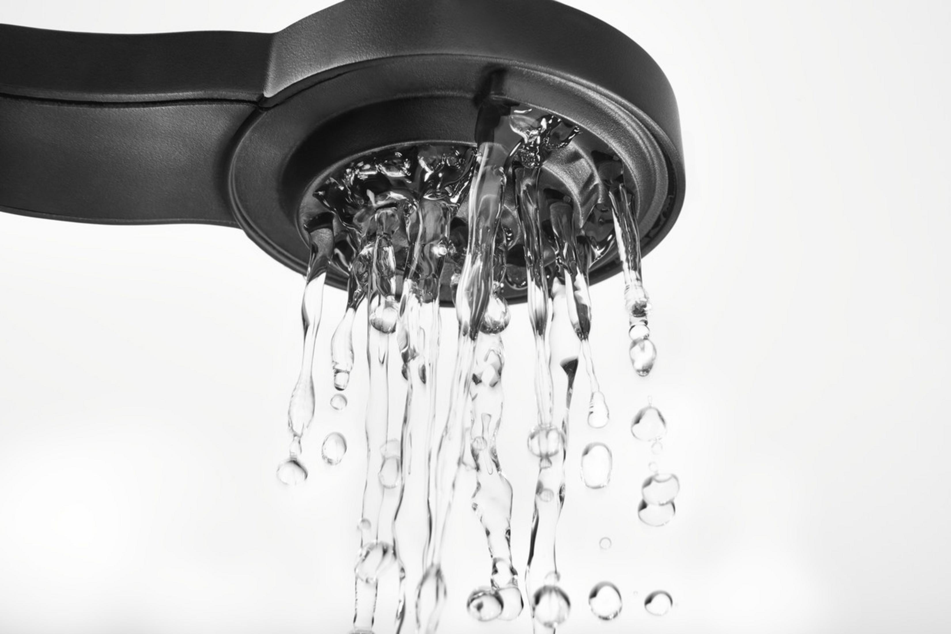 Zbliżenie czarnej głowicy prysznicowej z płynącą w dół wodą.