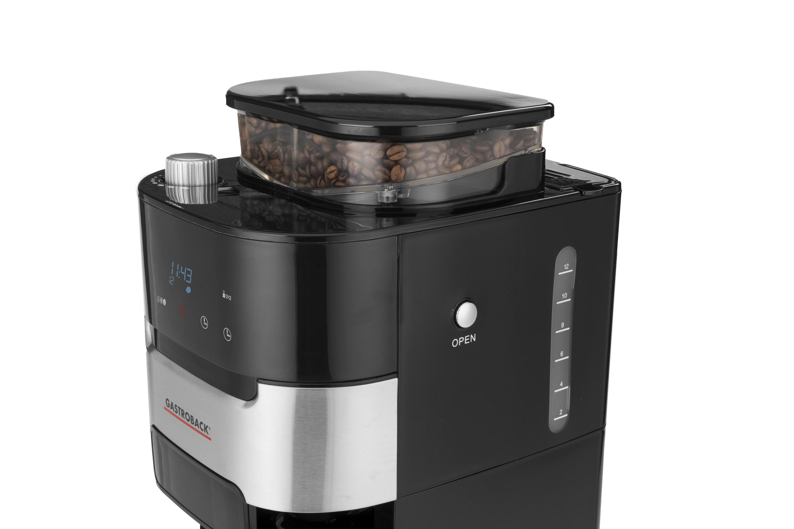 Una caffettiera nera con un contenitore trasparente per i chicchi sopra. Sfondo: bianco.