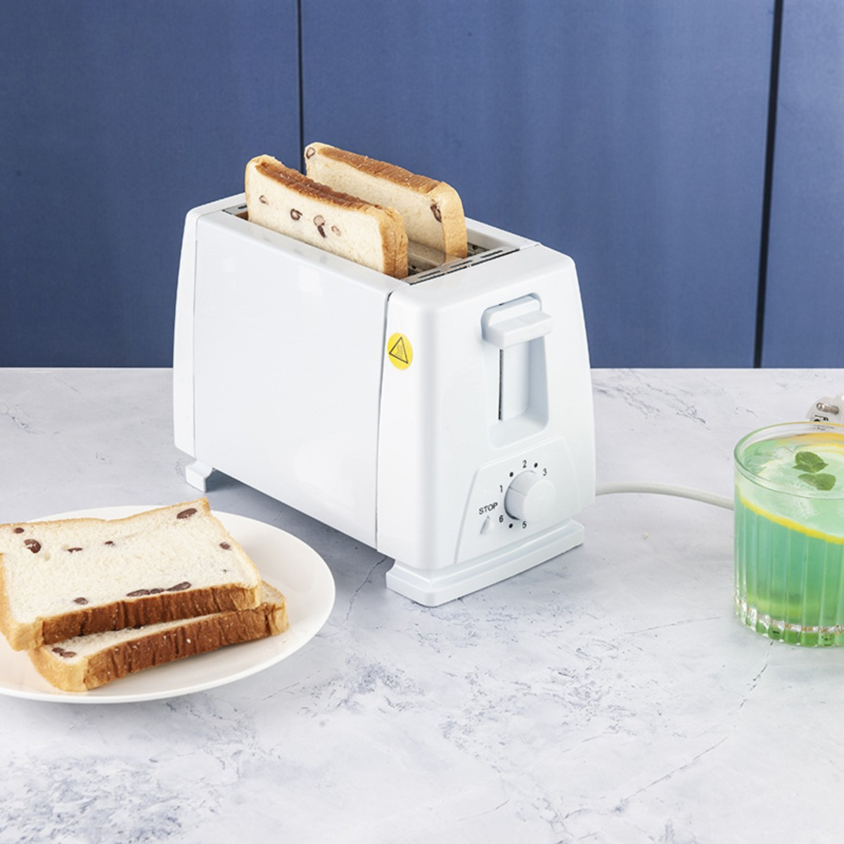 Weißer Toaster mit Toast und anderem Brot auf einer Oberfläche mit Getränk.