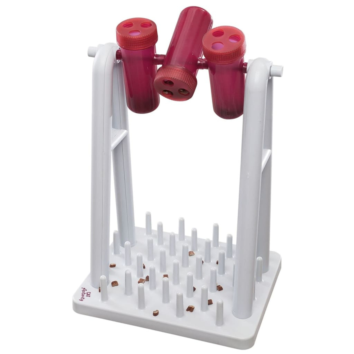 Biała i szara zabawka dla kota z trzema różowymi cylindrami i podstawą z kołkami, z rozsypanymi smakołykami.