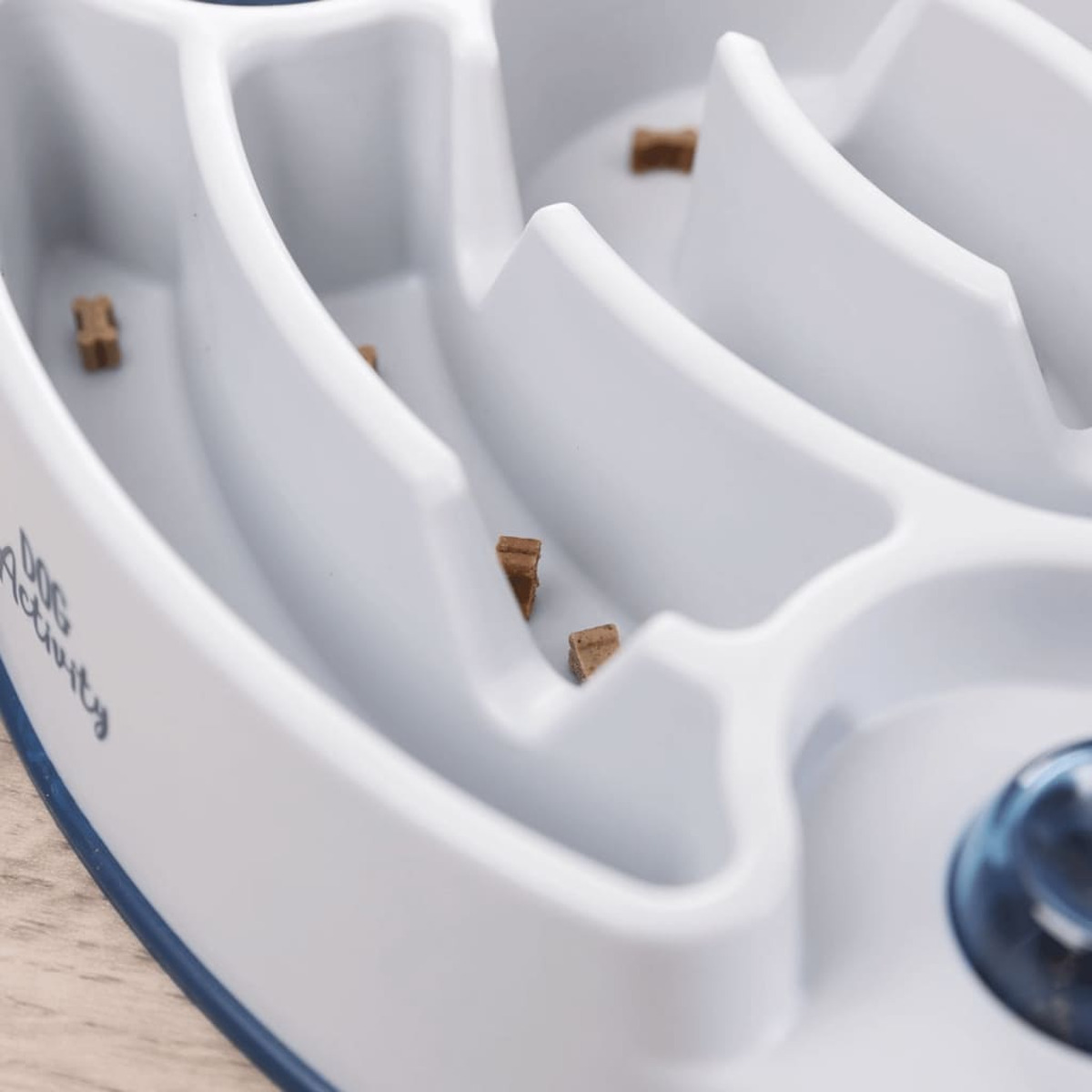 Biała miska do karmienia psa z kawałkami karmy w środku.