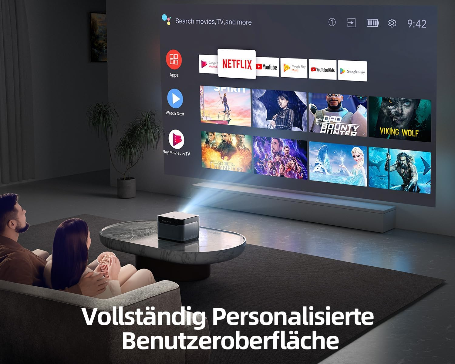 Leute schauen einen Film auf einem großen Bildschirm. Ein Projektor steht auf dem Tisch. Text: Vollständig Personalisierte Benutzeroberfläche.