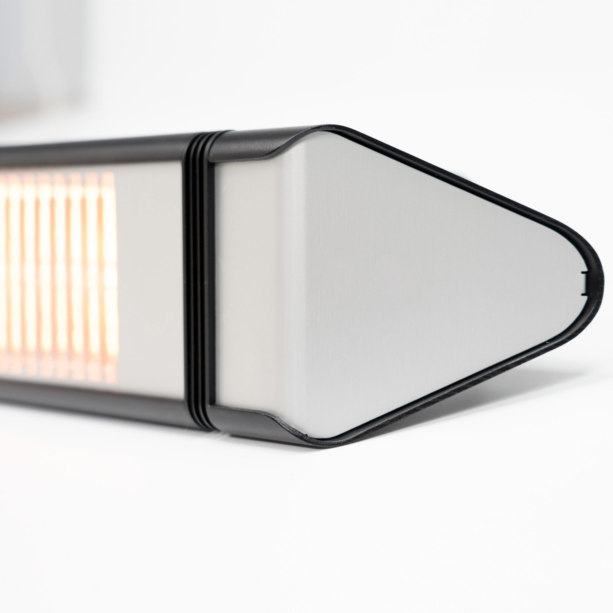 Nahaufnahme eines silber-schwarzen rechteckigen Heizgeräts mit einer Lichtquelle links.