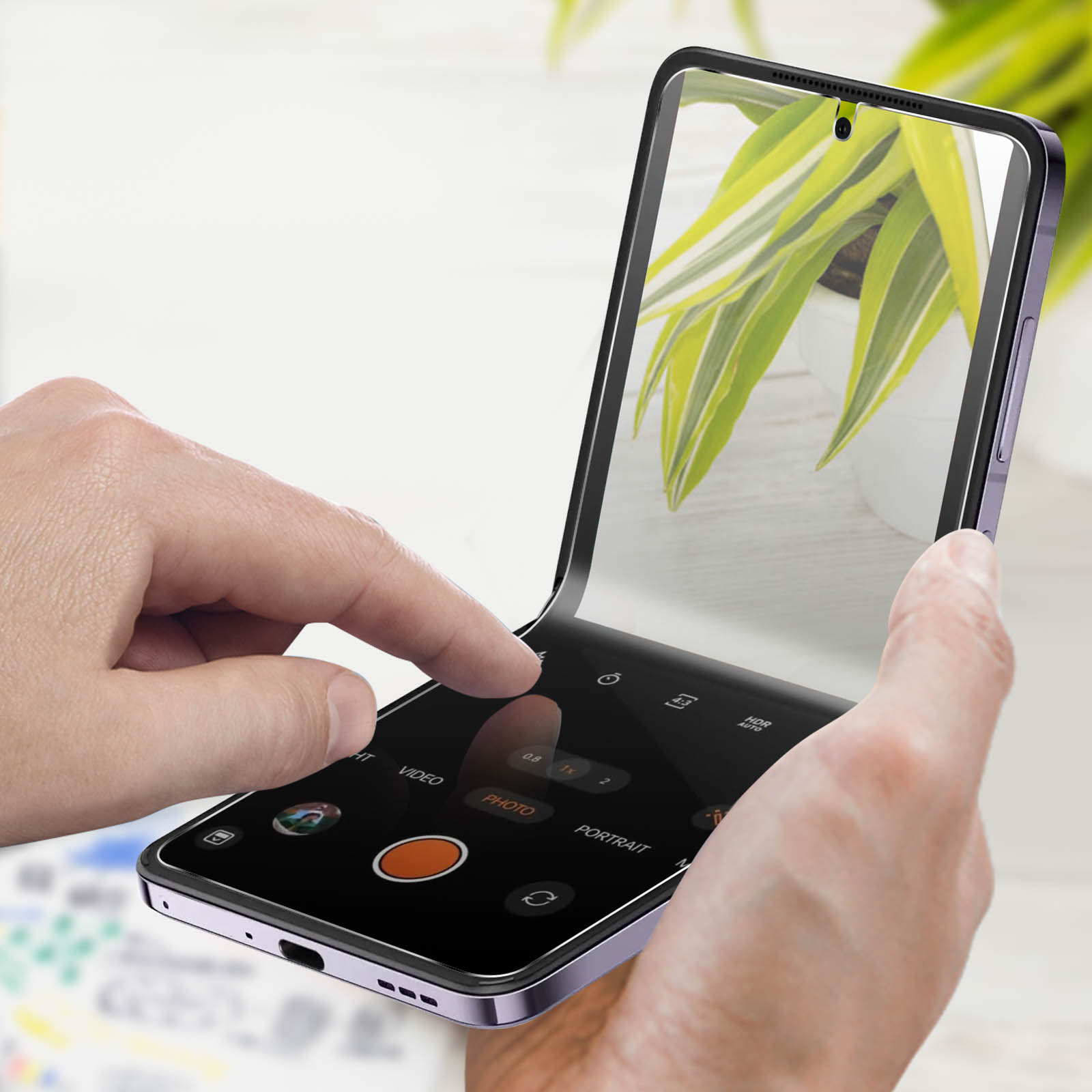 Mains tenant un smartphone pliable avec l'interface de caméra ouverte.
