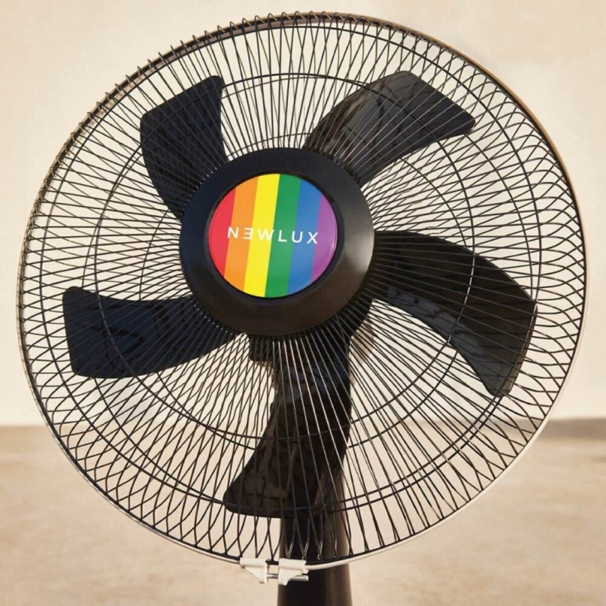 Ventilador negro con centro arcoíris, 'NEWLUX', aspas inclinadas, sobre fondo blanco.