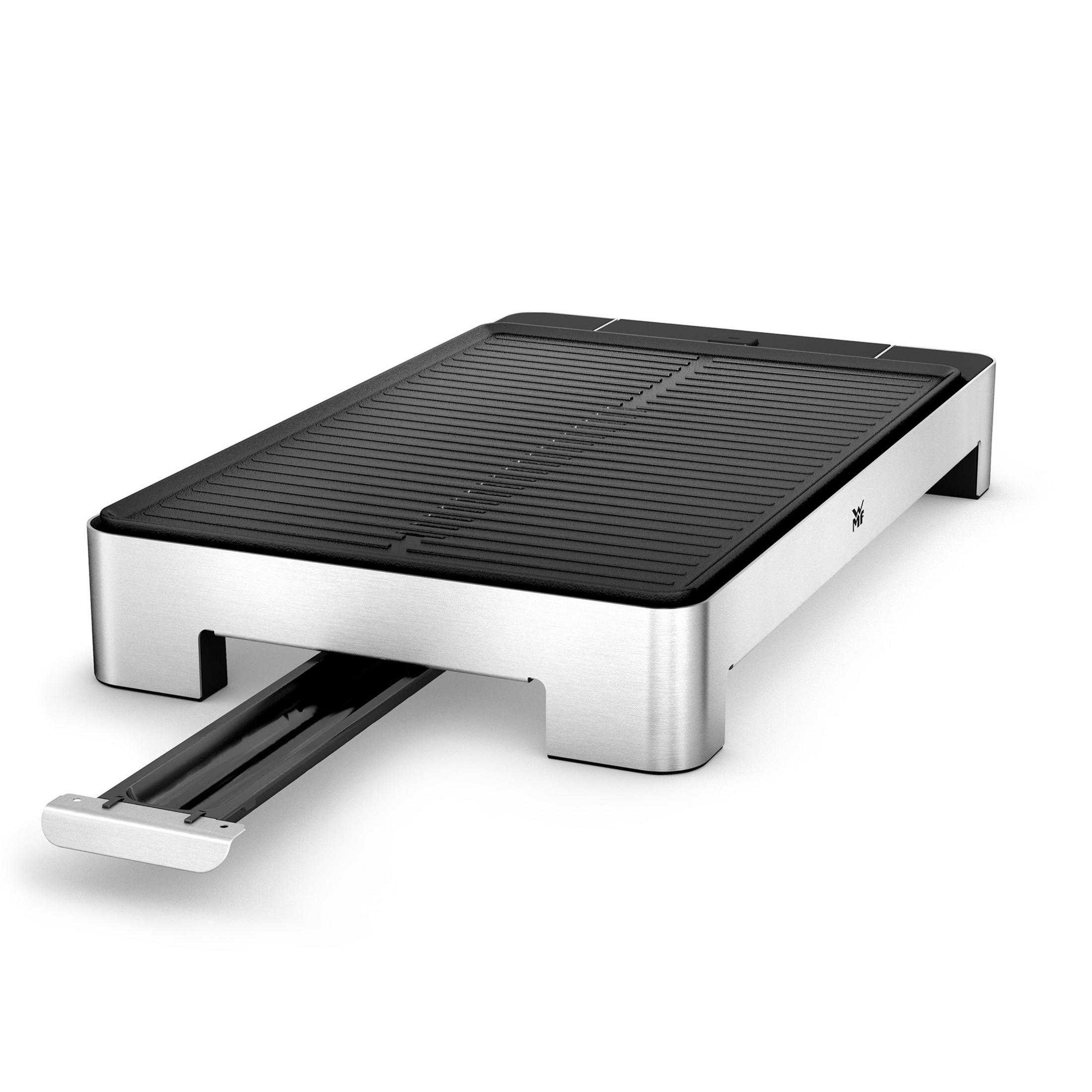 Ein silberner Grill auf einem silbernen Sockel. Es ist eine flache Oberfläche. Der Grill hat eine Schublade.