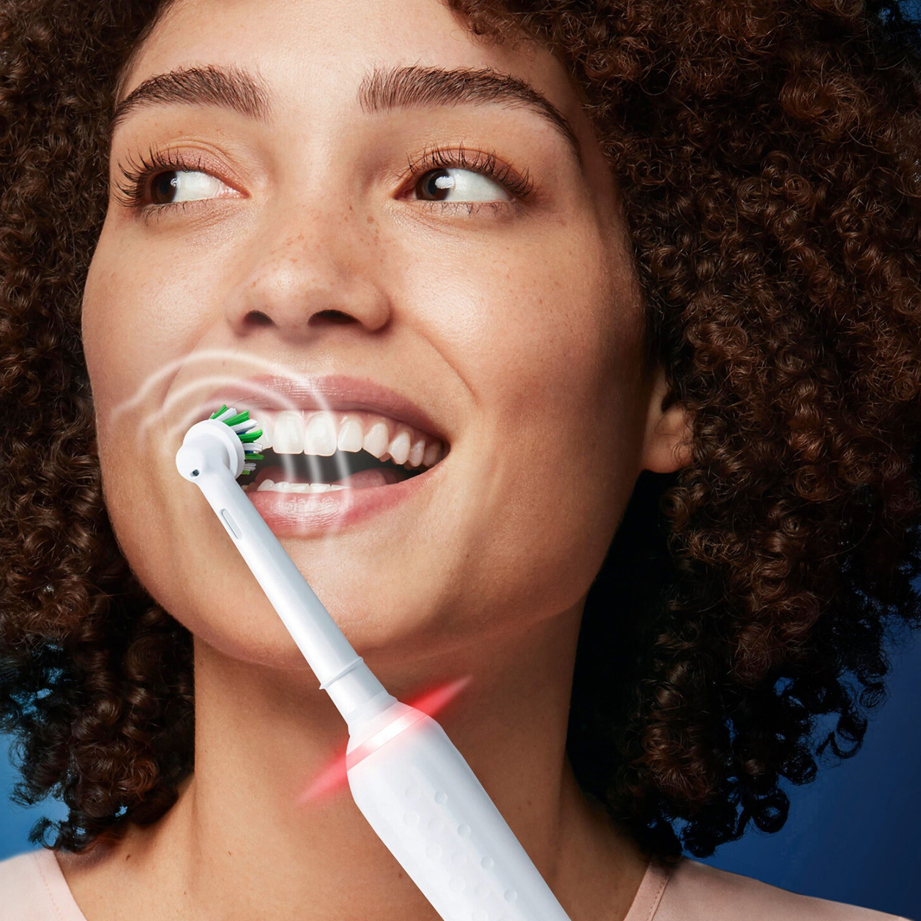 Kobieta myjąca zęby białą szczoteczką, skupienie na ustach.