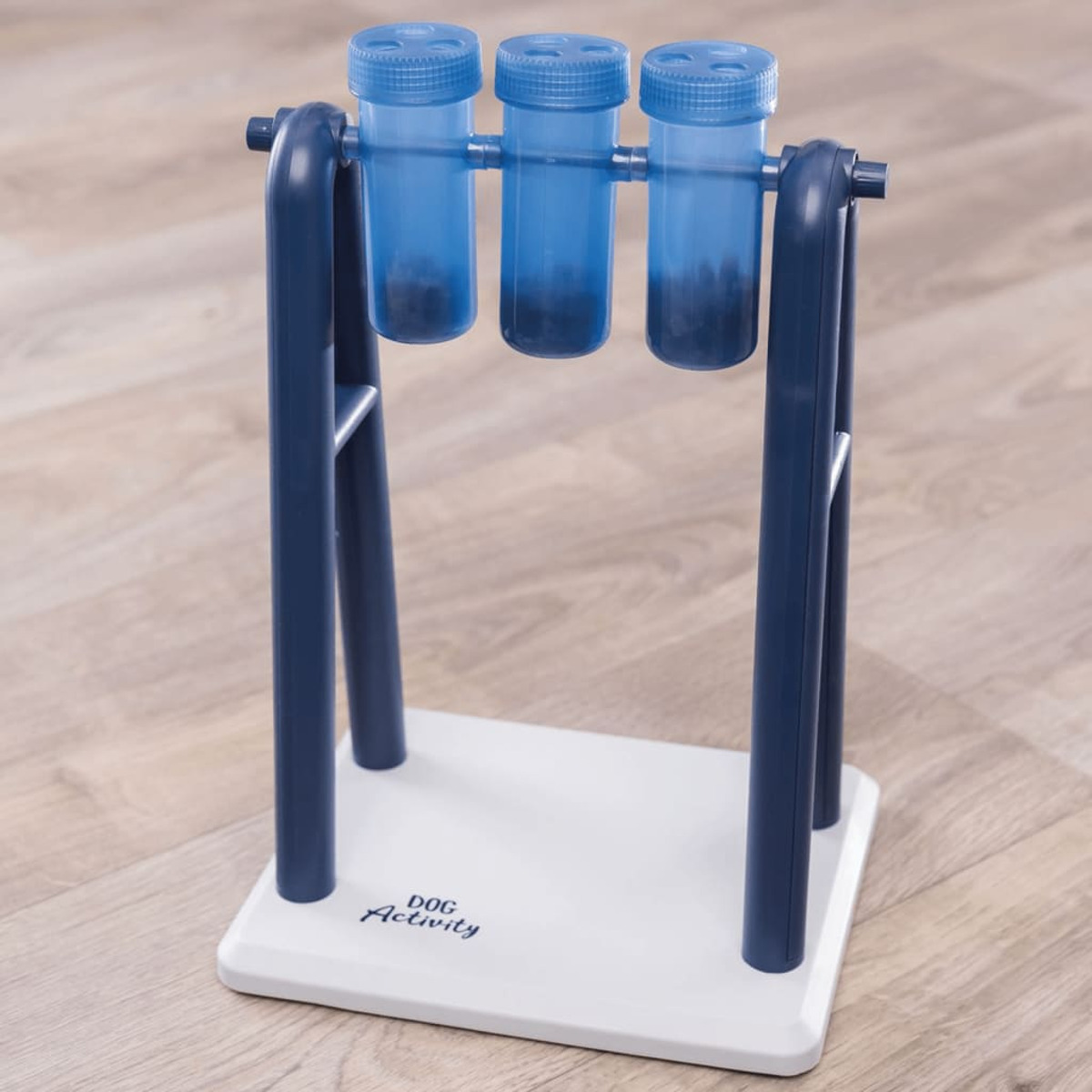 Zabawka dla psa z niebieskimi tubami zawierającymi przysmaki, na białej i niebieskiej podstawie.
