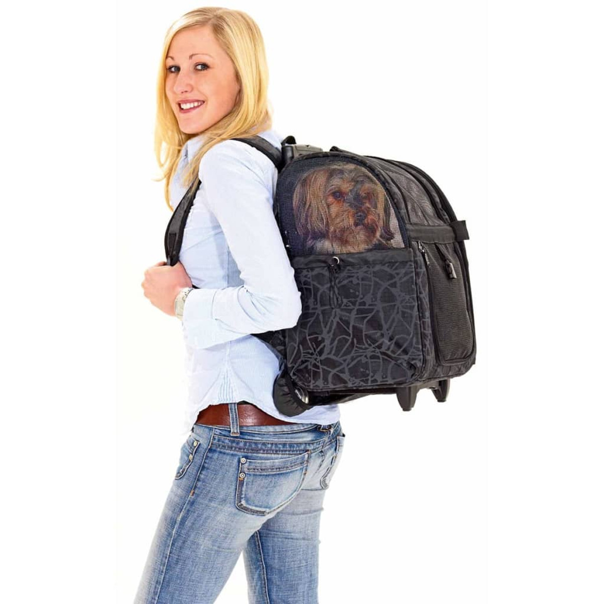 Eine Frau mit Hund in einem Reise-Rucksack, lächelt in die Kamera auf weißem Hintergrund.