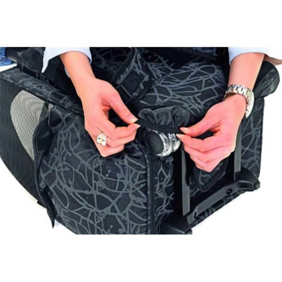 Hände, die eine Tasche schließen. Die Tasche befindet sich auf einem Gepäckträger.