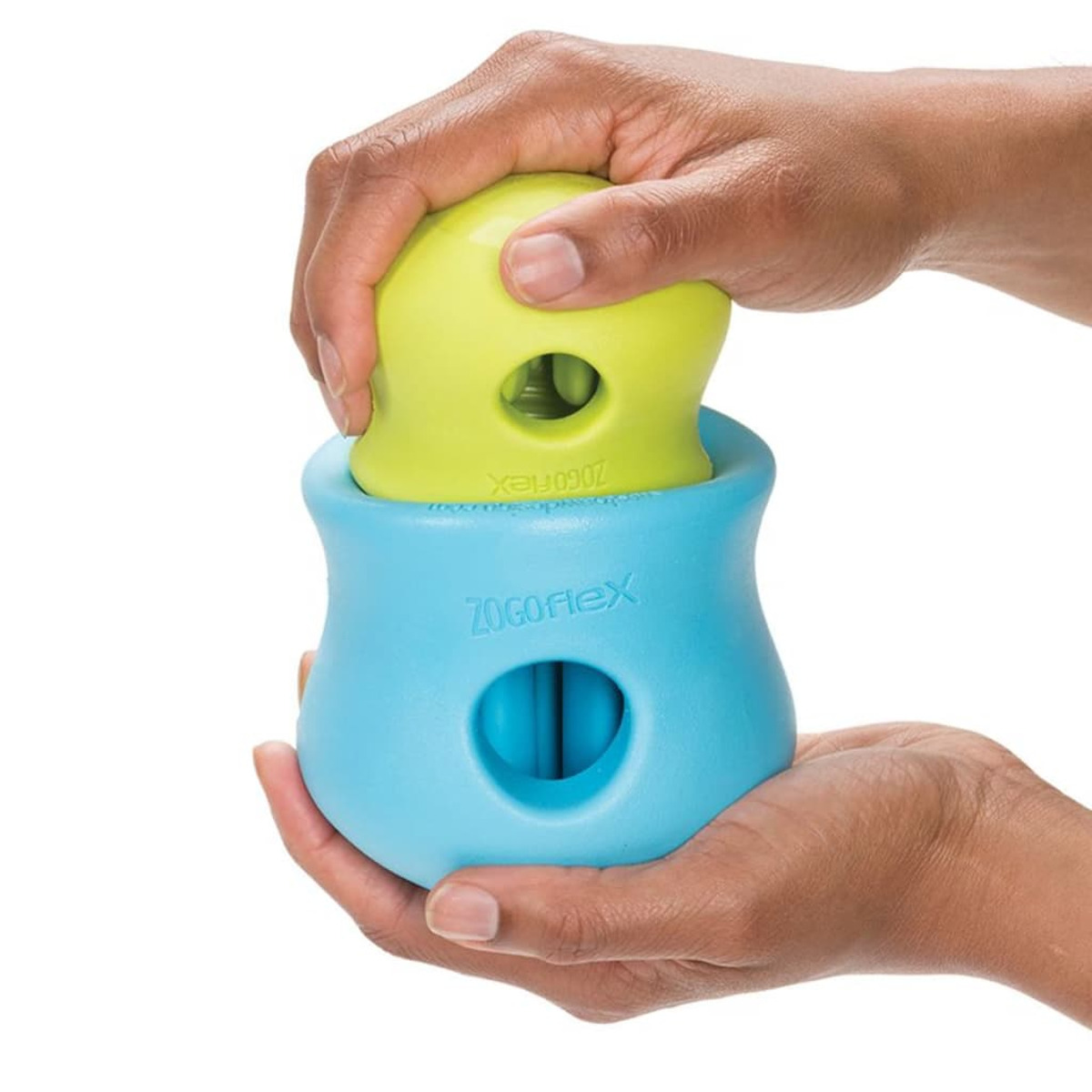 Mani che tengono un giocattolo per cani blu e verde. Una parte si inserisce nell'altra.